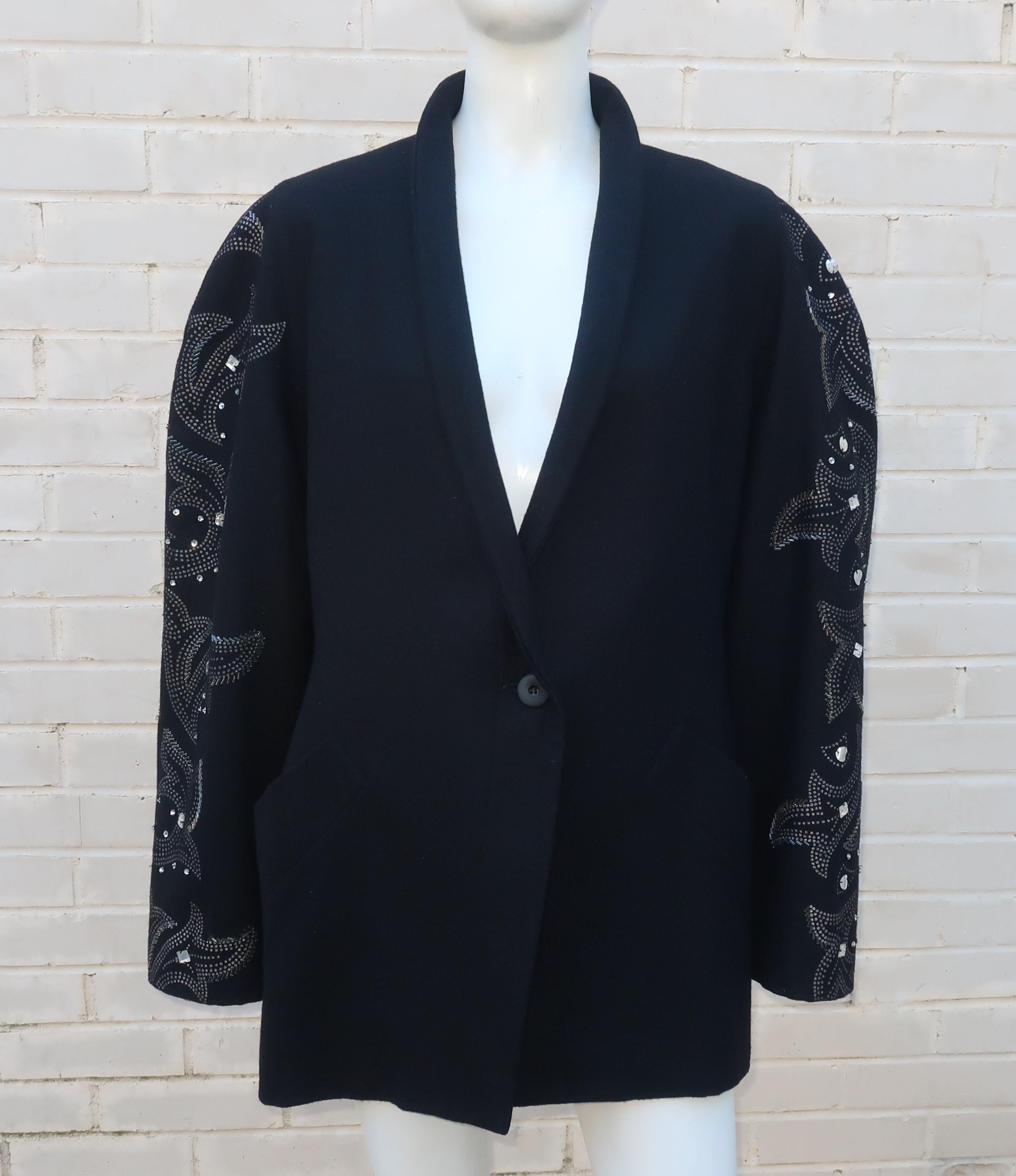 This 1980’s Byblos black wool jacket has a disco vibe with sleeves embellished by a silver print, faceted stones, sequins and beads.  The shawl collar, rounded shoulder line and simple single button front give the design a tux or boyfriend jacket