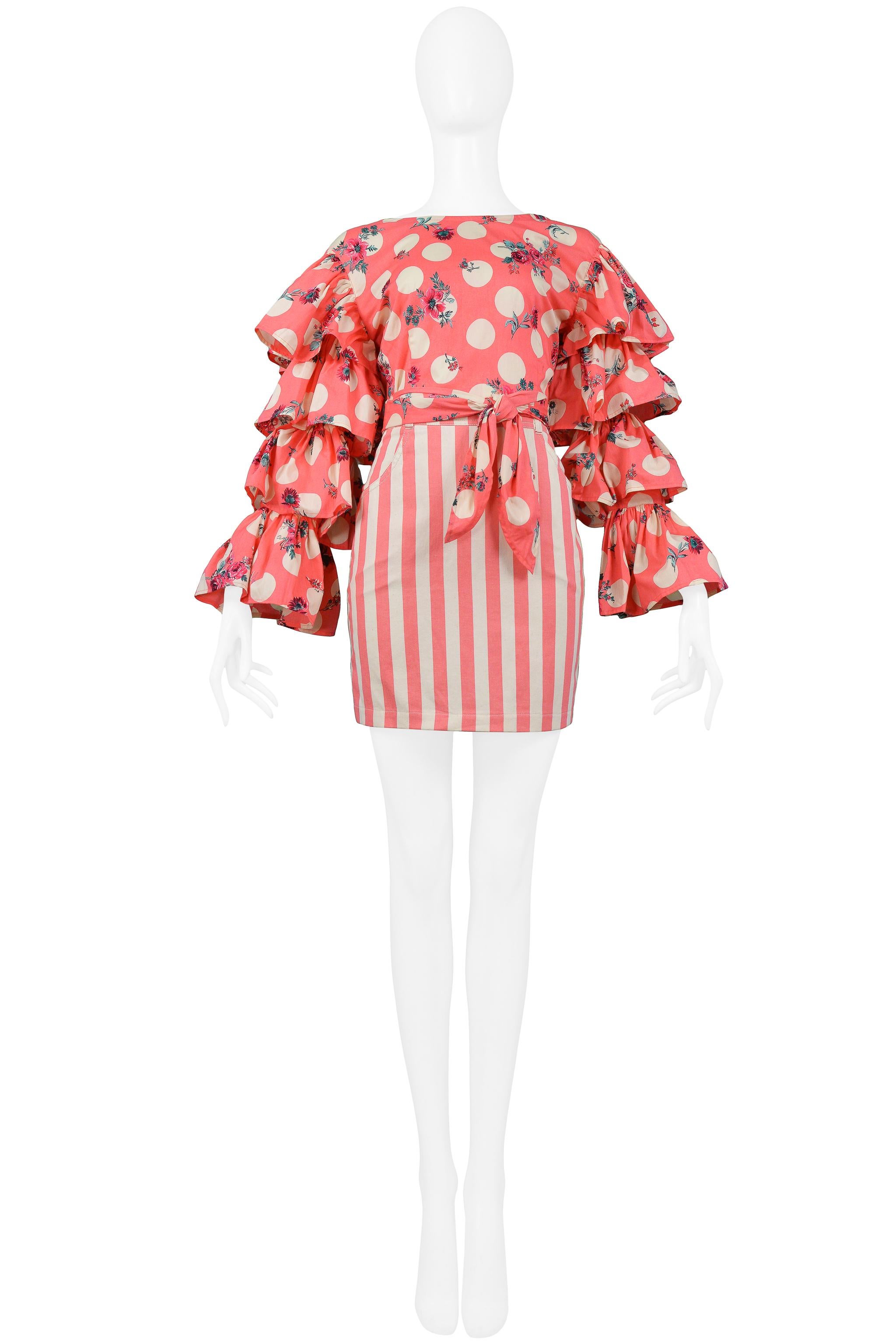 Resurrection Vintage is excited to offer a vintage Byblos hot pink and cream polka dot and floral print Byblos cotton wrap top with ruffled sleeves and matching pink and cream stripe skirt with center zipper and button closure. 

Byblos
Designed by
