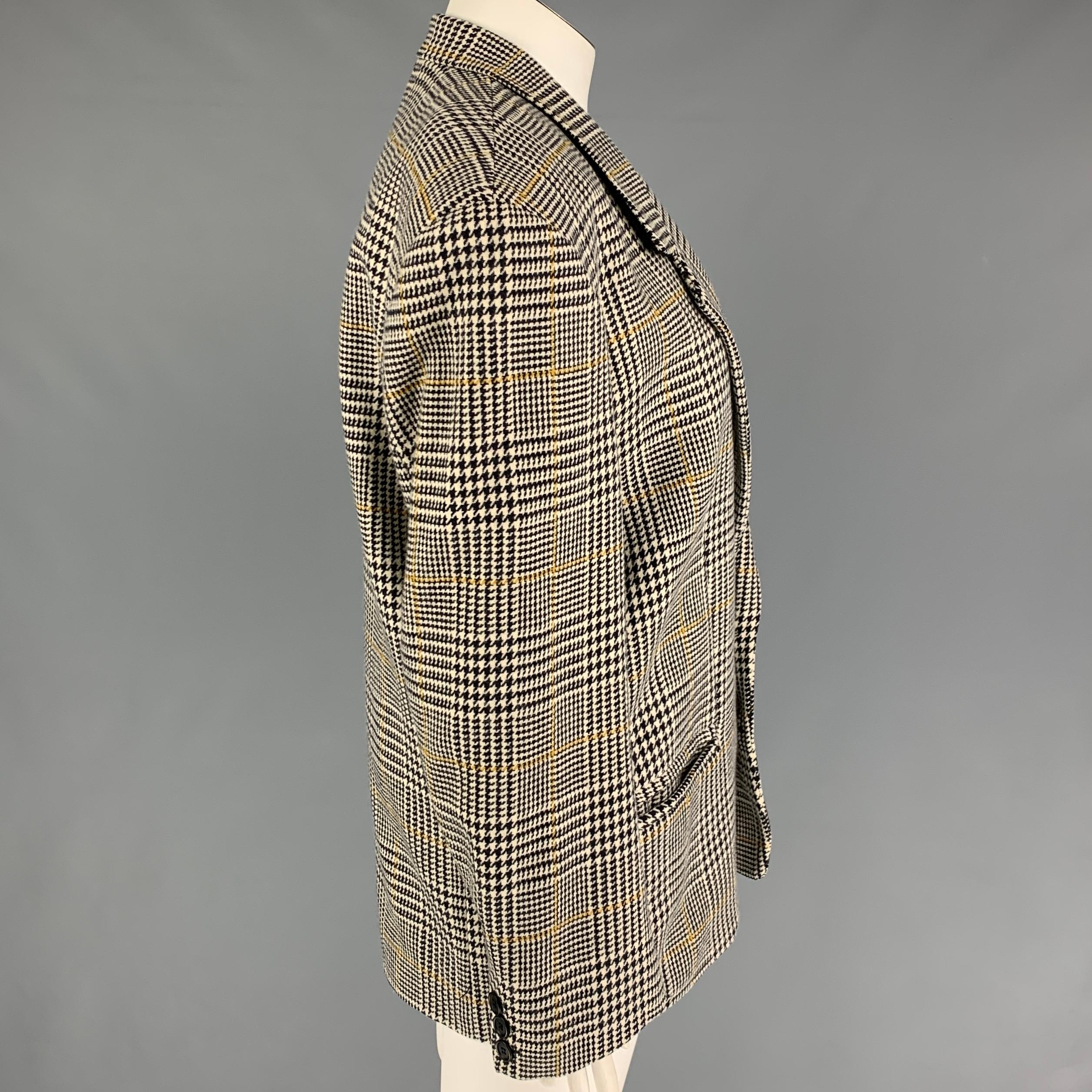 BYBLOS blazer comes in a black & white houndstooth viscose with a full liner featuring a notch lapel, slit pockets, and a double button closure. Made in Italy. 

Very Good Pre-Owned Condition.
Marked: I 50 / F 48 / D 44 / GB 42 / BS 46 / USA