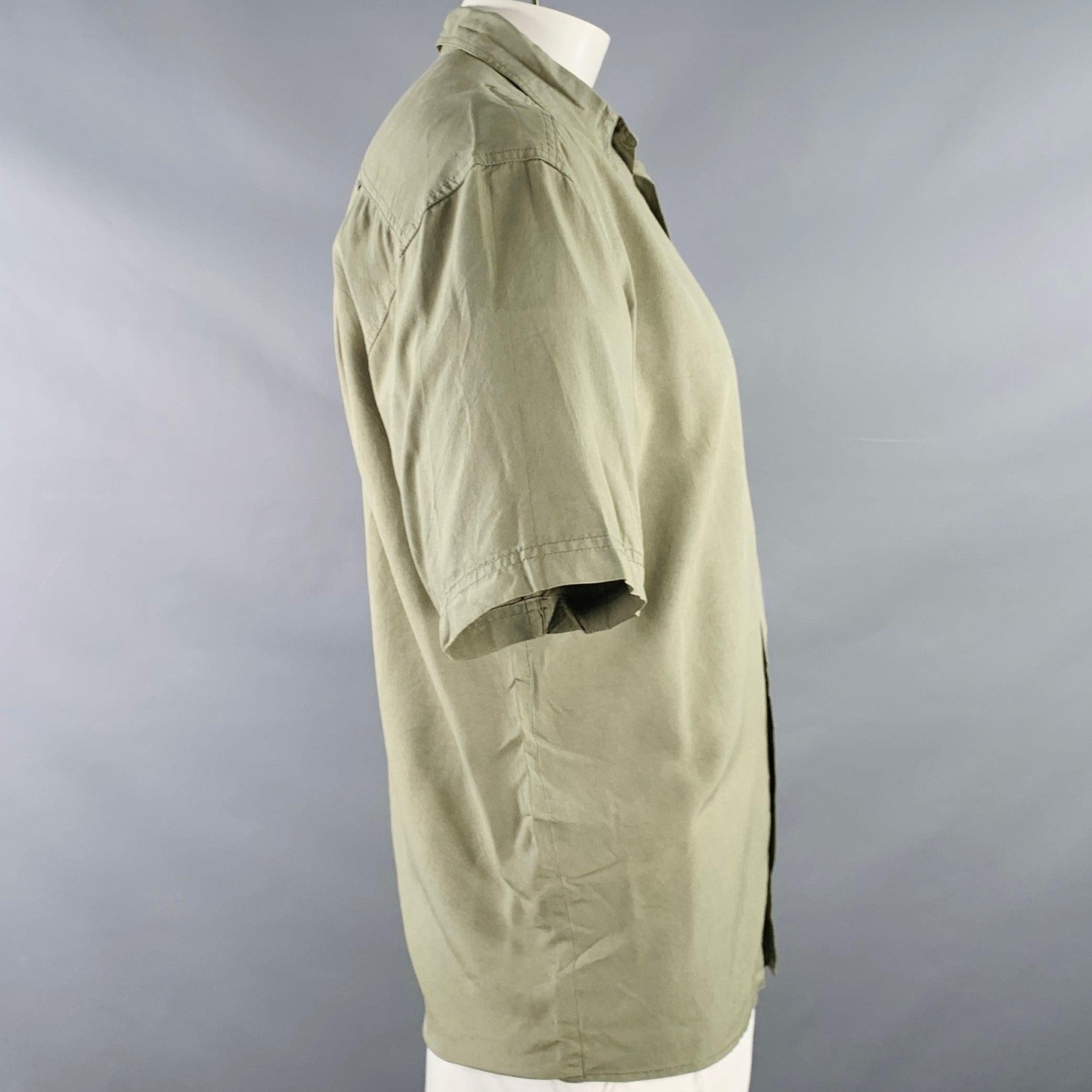 BYBLOS Kurzarm-Shirt
aus olivgrüner Seide mit breitem Kragen, einer geknöpften Tasche und Knopfverschluss. Made in Italy Ausgezeichneter Pre-Owned Zustand. 

Markiert:   46 

Abmessungen: 
 
Schulter: 20 Zoll  Brustkorb: 46 Zoll  Ärmel: 10 Zoll