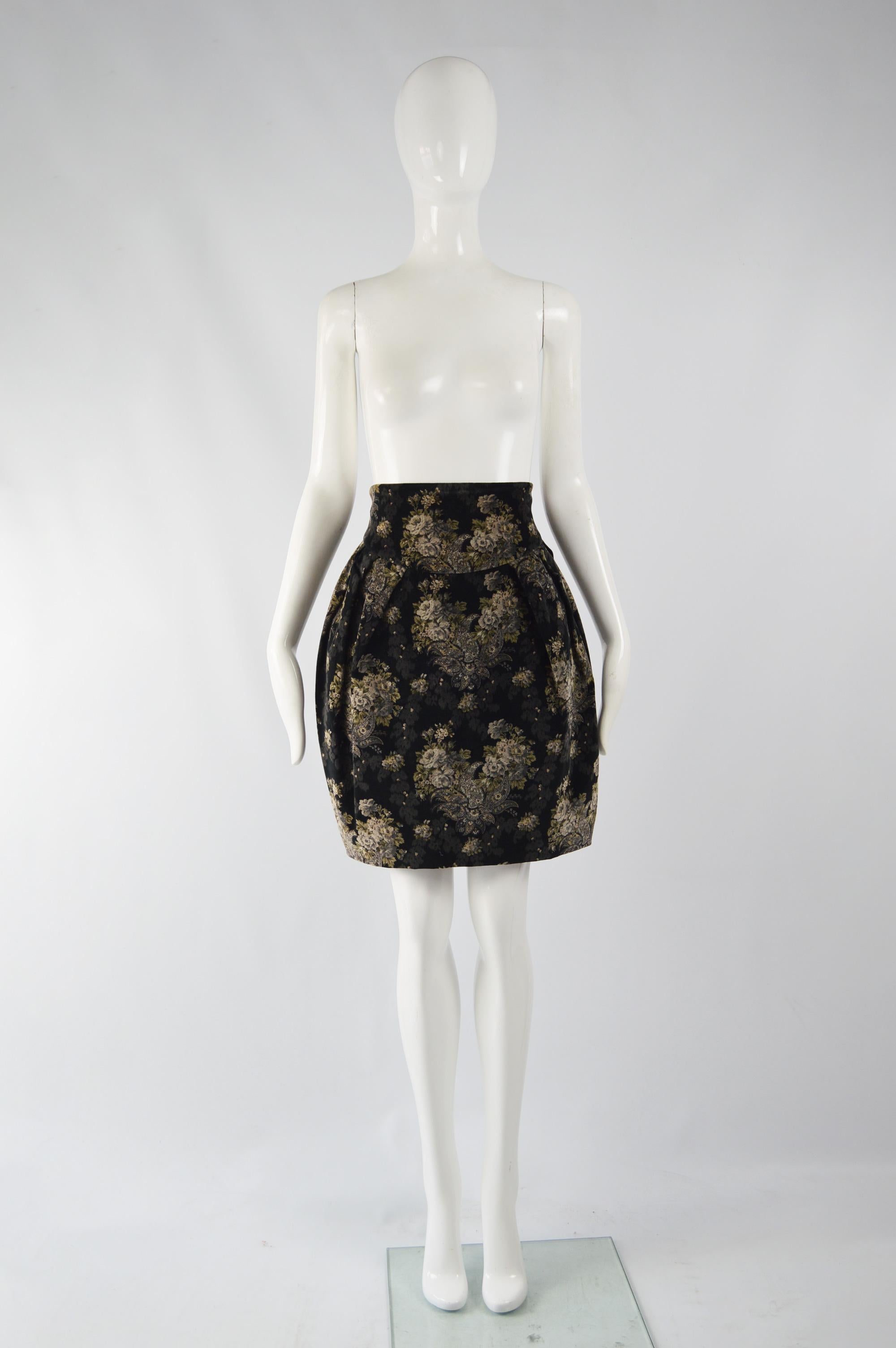 A chic vintage women's skirt from the 80s by luxury Italian fashion house Byblos (who Gianni Versace was once a creative director of). In a black velvet with a grey and beige floral pattern throughout and an ultra high waist that contrasts with the