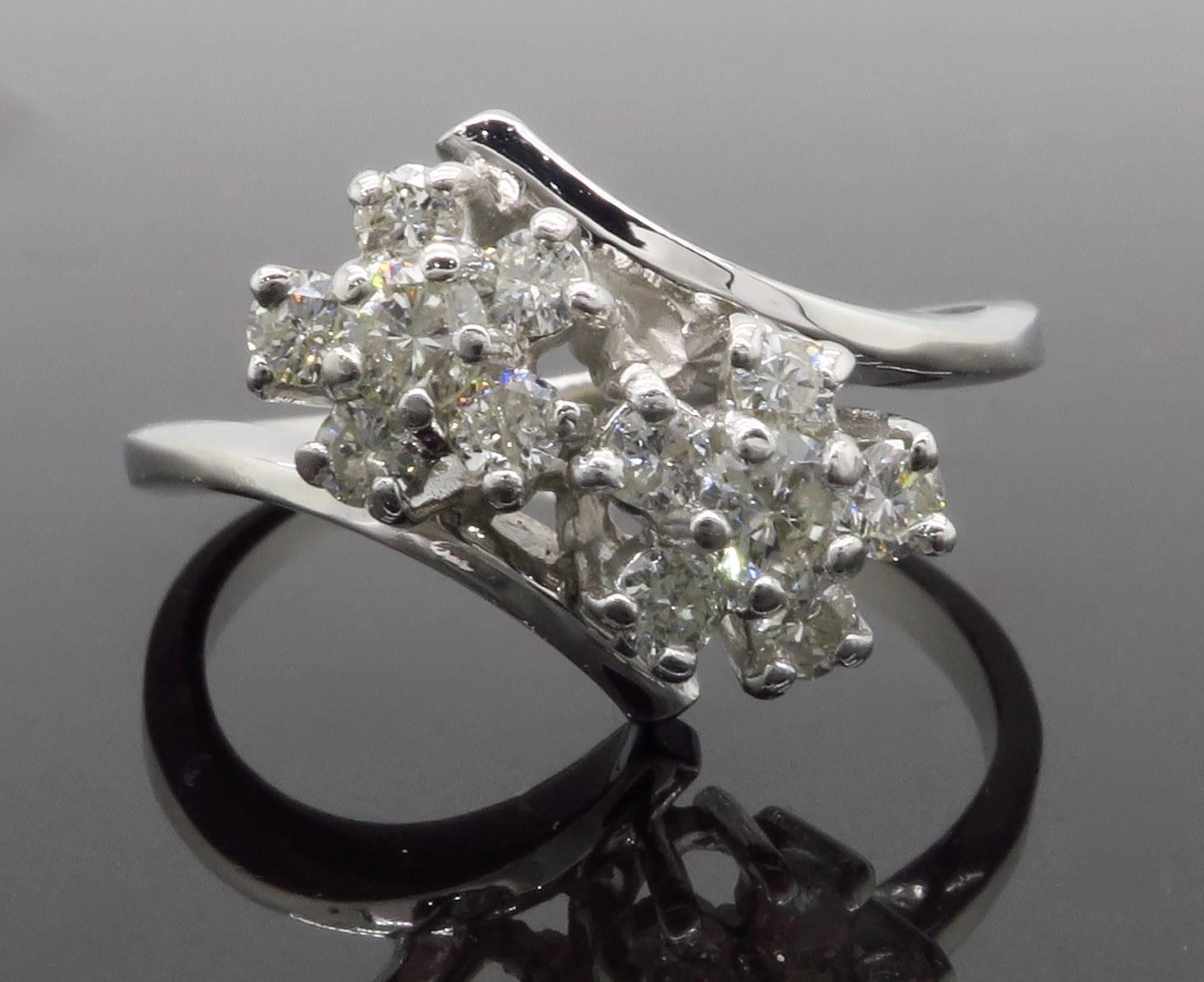 This stunning floral design bypass style ring features 12 Round Brilliant Cut Diamonds. The diamonds display an average color of G-I and an average clarity of I1-I2. There is approximately .51CTW of diamonds in this ring. The 14k white gold ring