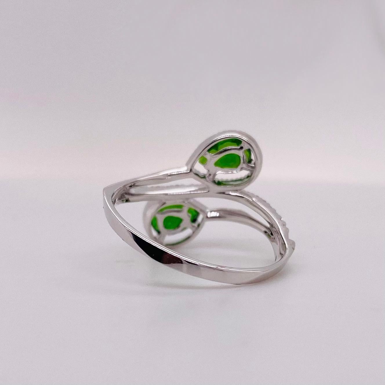 This rocking ring has a bypass design with two gorgeous pear shaped green Russalite. The white gold ring has a halo around each stone. The details for this beautiful ring are listed below:
Metal Quality: 14 k White Gold 
Diamond Number: 23
Diamond