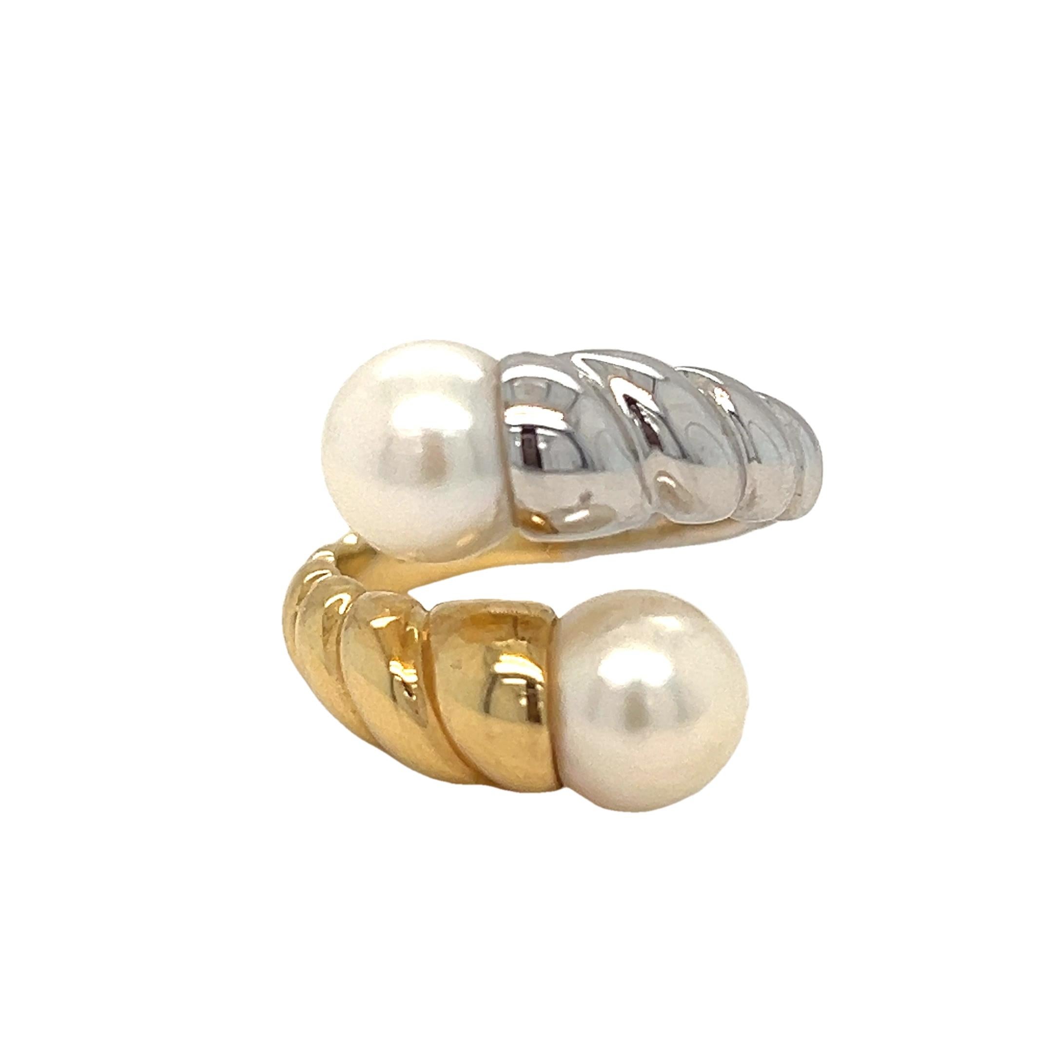 This elegant bypass ring features two lustrous 8mm pearls set in a sophisticated two-tone 18K gold design. The band is crafted with a twisted ridge pattern, adding texture and a unique flair to the classic bypass style. With its timeless look and