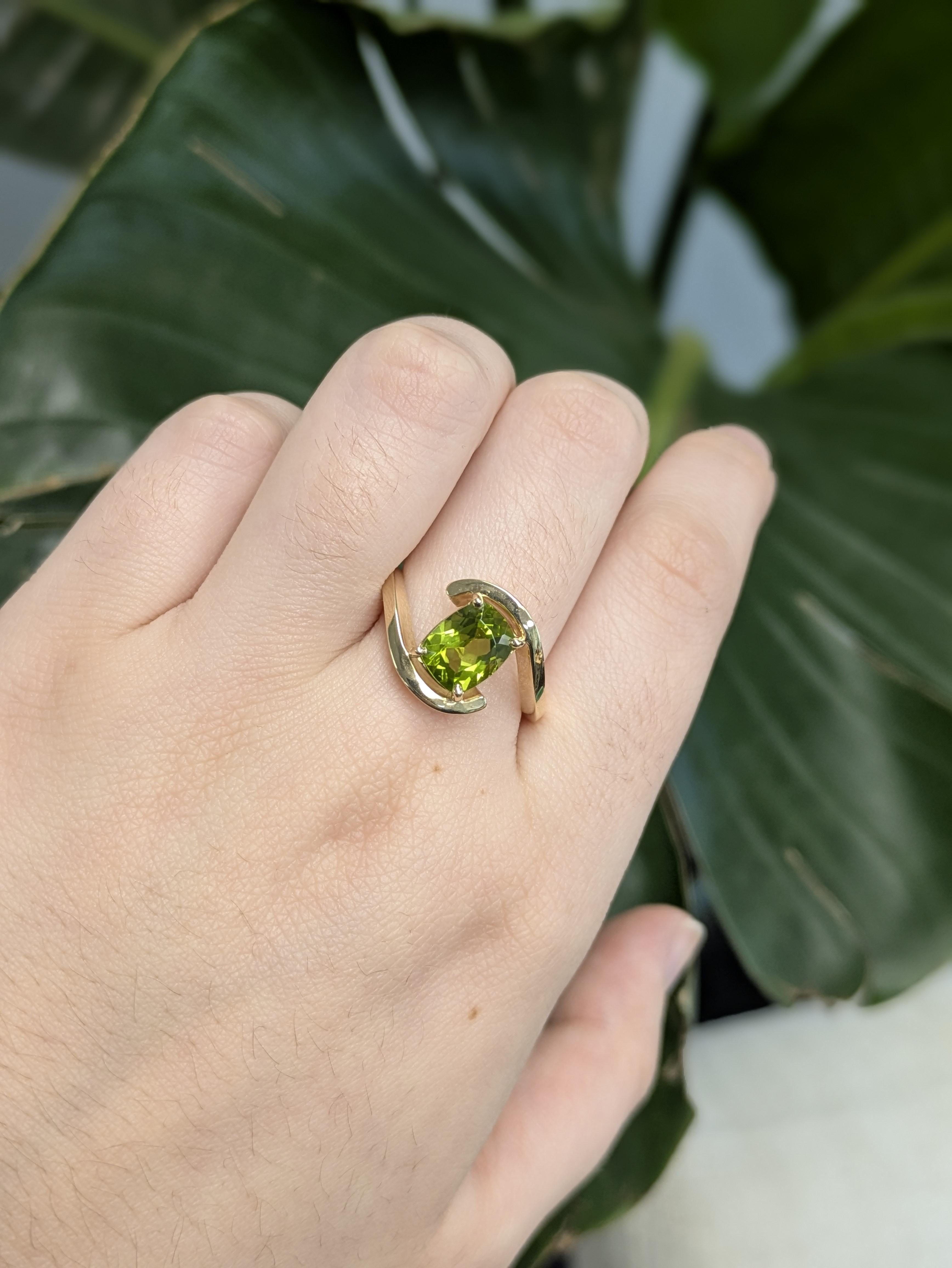 Rein, modern und strahlend - dieser 2,13 Karat schwere Peridotring im Kissenschliff aus Arizona bietet eine neue Interpretation des Solitärs. Der leuchtende 9x7 mm große Edelstein ruht in massivem 14-karätigem Gelbgold, das durch einen glatten
