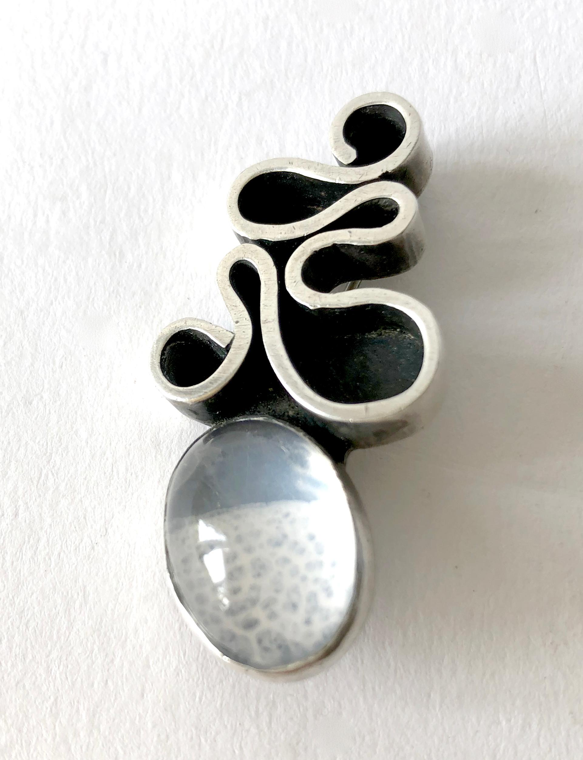 Sterling silver and moonstone squiggle brooch created by Byron Wilson of San Francisco, California. Brooch measures 1 3/4