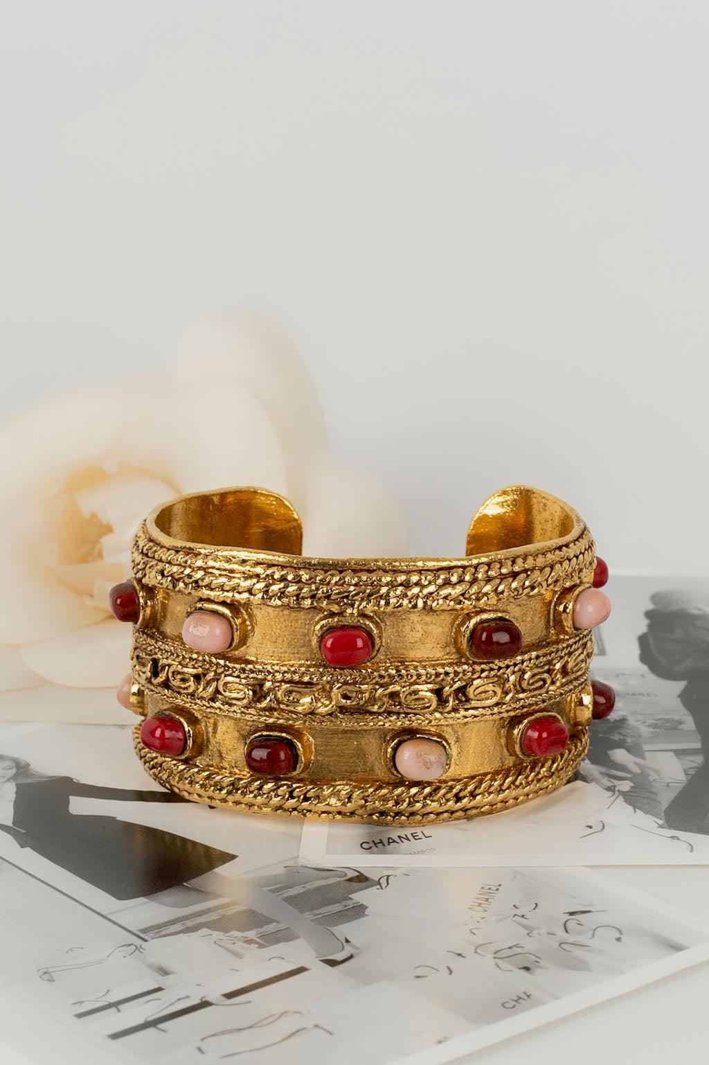 Chanel -(Made in France) Gold metal cuff bracelet paved with glass paste cabochons. Jewel dating from the 1980s.

Additional information:

Dimensions: 
Circumference: 16 cm 
Opening: 3 cm 
Width: 4.5 cm

Condition: Very good condition
Seller Ref