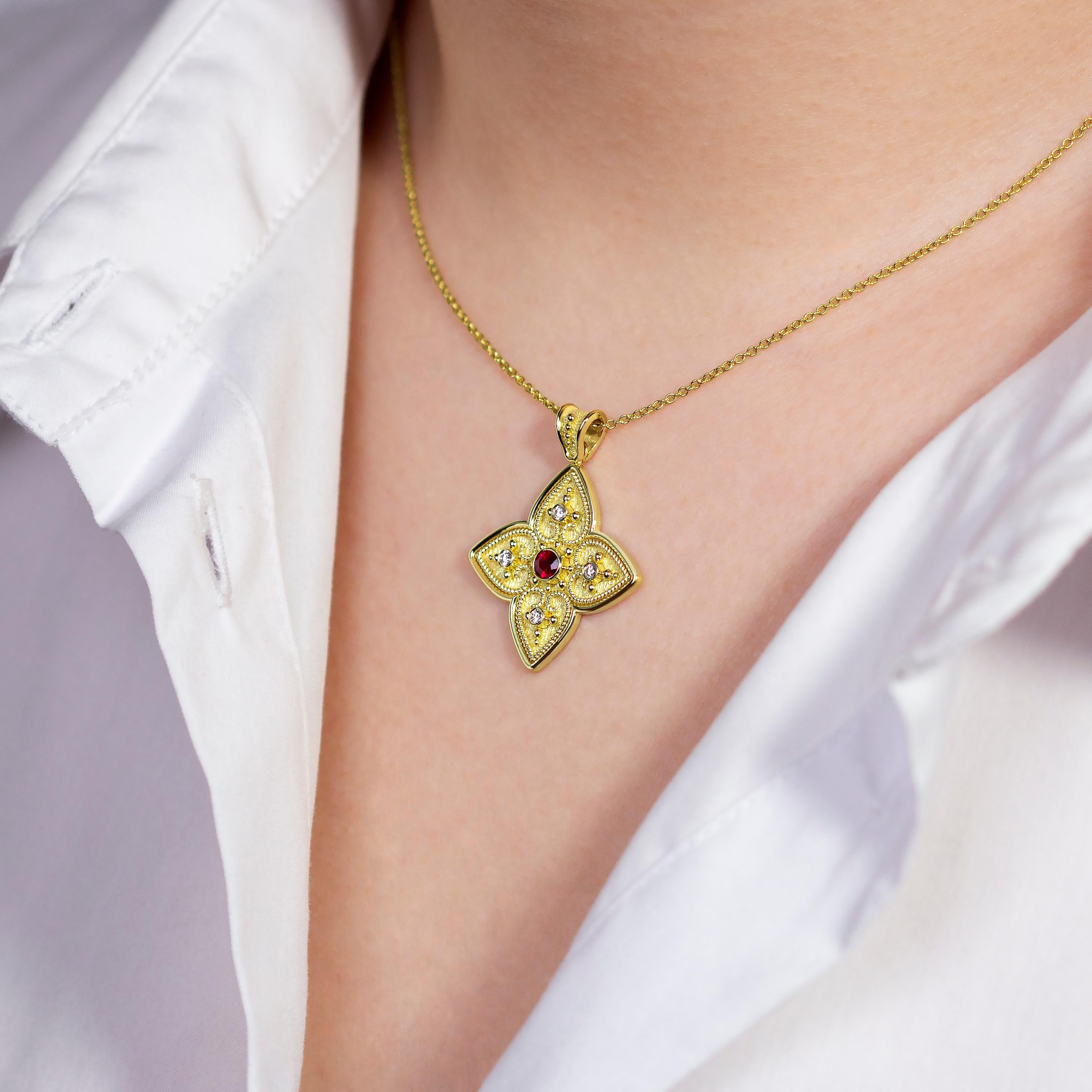 Unser einzigartiger Kreuzanhänger aus Gold erblüht mit einem bezaubernden Blumendesign, bei dem herzförmige Blütenblätter jeweils einen einzelnen Diamanten umschließen, der von einem strahlenden Rubin umgeben ist. Ein Symbol der Liebe und des