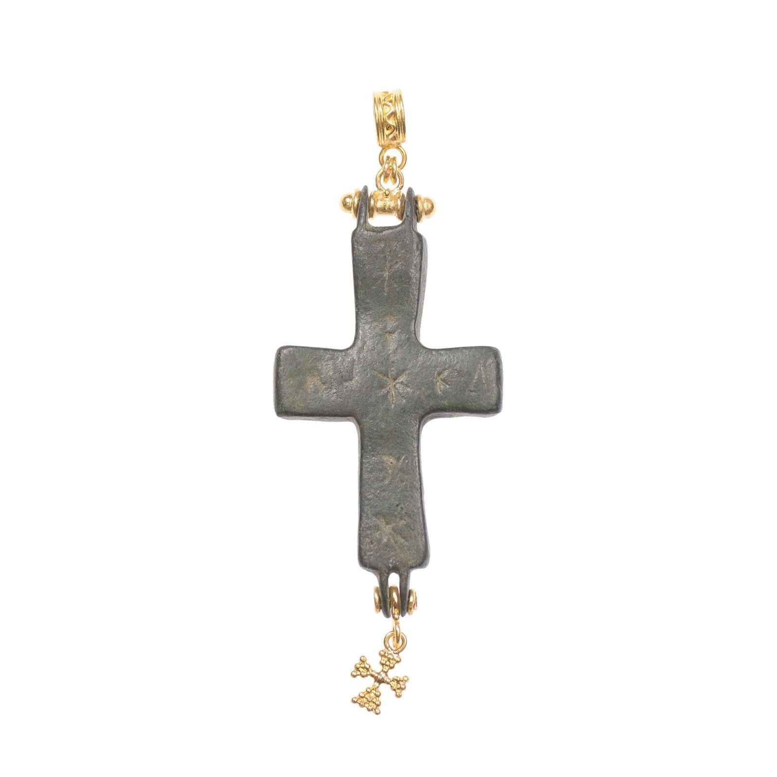 Pendentif en forme de croix byzantine avec une monture pendante en or 21K et une double boucle fixe au sommet. Cette croix en bronze date du 4e au 6e siècle ADS ; elle a probablement été créée par fonte à la cire perdue, puis les autres décorations