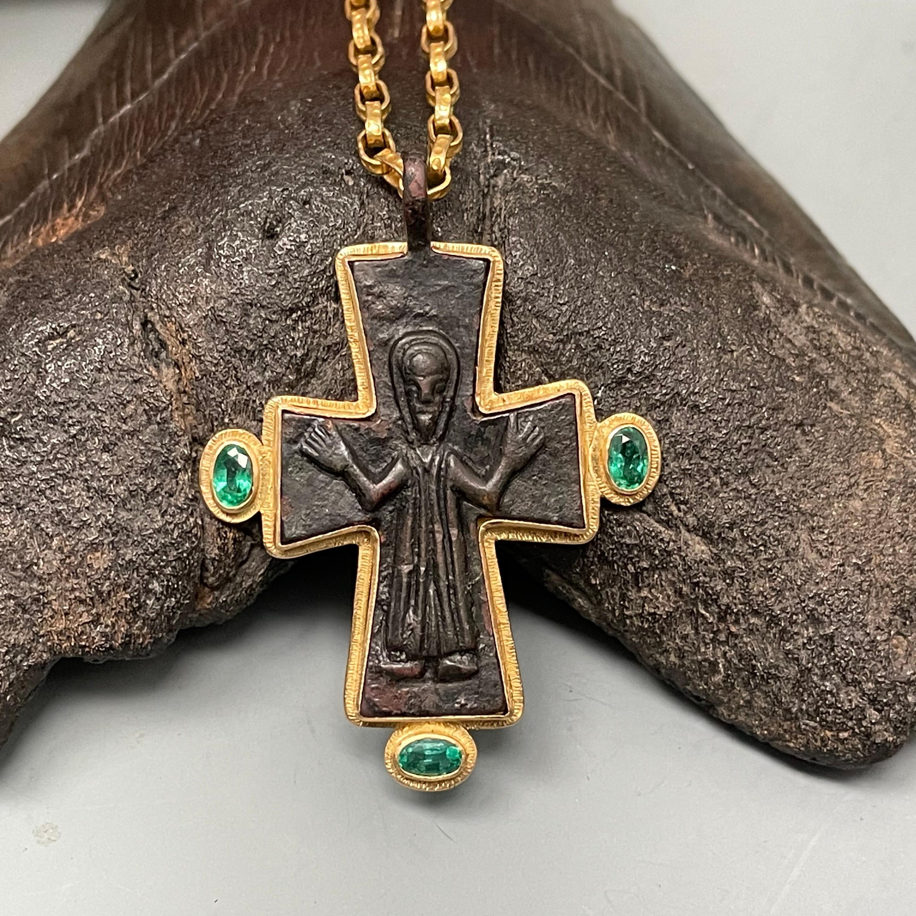 An authentic 8th to 11th century reliquary bronze cross from the Byzantine Empire, featuring Christ with arms out-stretched, has been ornamented with a Steven Battelle designed surrounding 18K gold line textured bezel and three 3 x 5 mm faceted