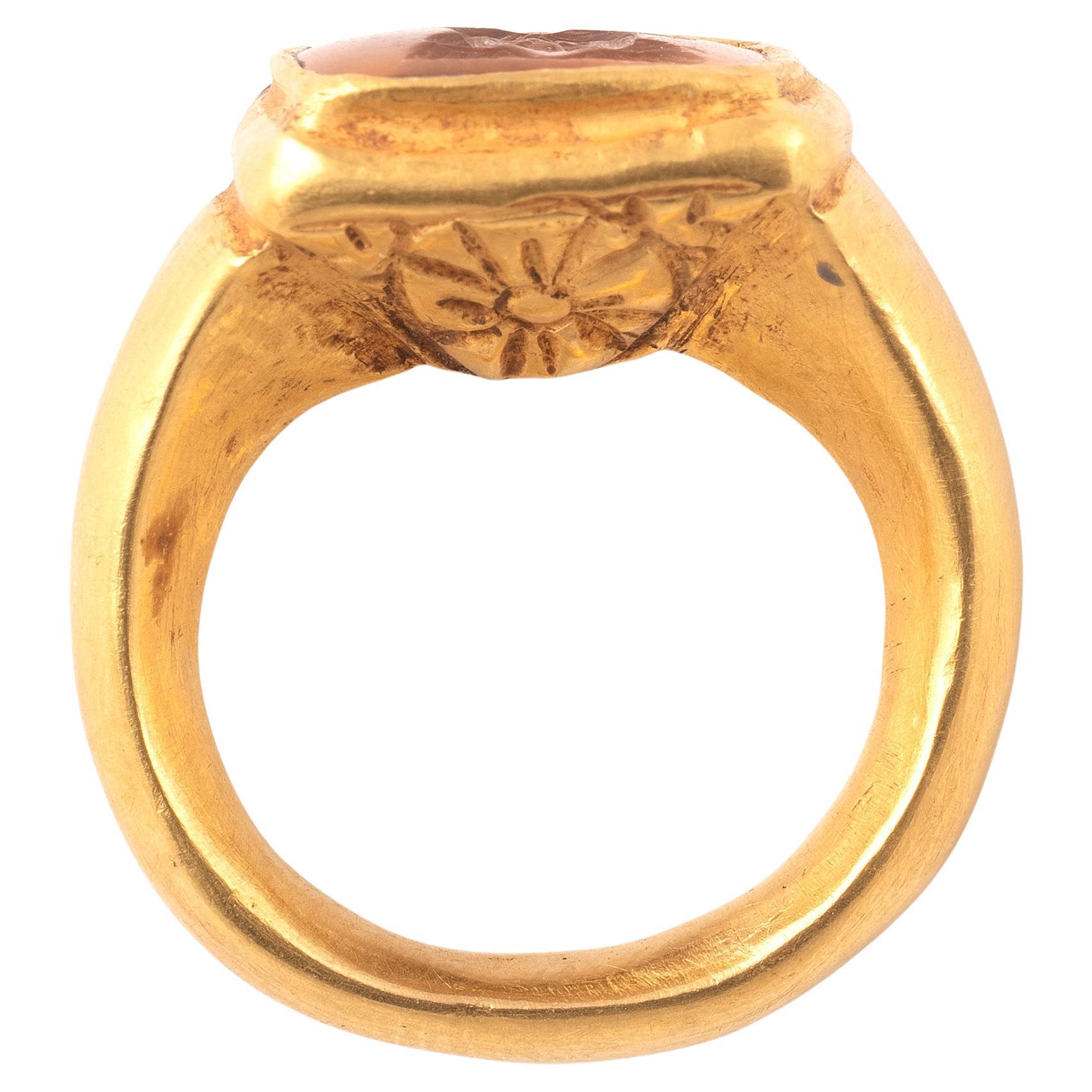 Bague byzantine en or, en feuille repoussée, ornée d'une intaille carrée en topaze représentant le buste du Christ avec un nimbe en forme de croix. La bague elle-même est faite d'une feuille d'or fine mais robuste, le dessous de la tige étant décoré