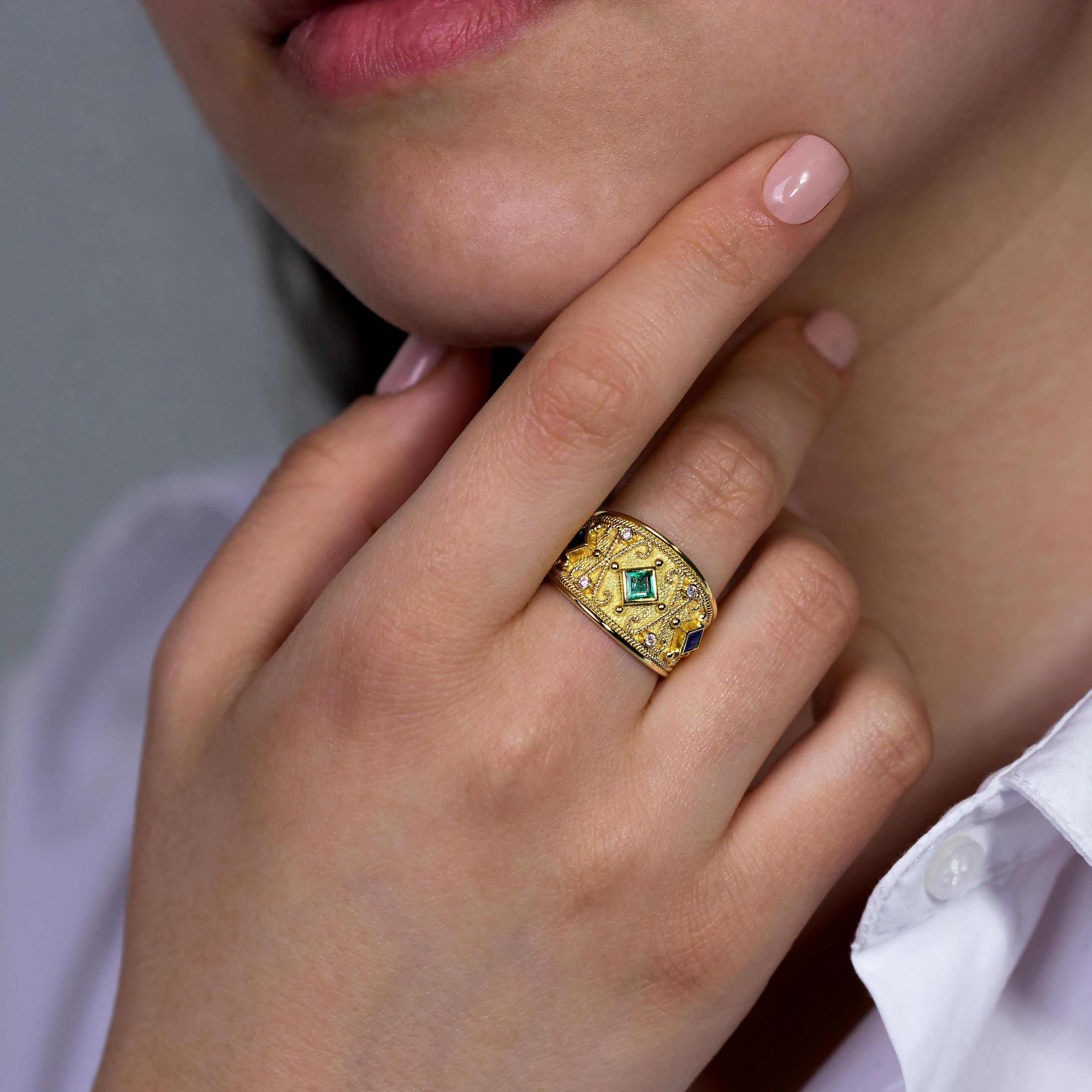 Indulge in the allure of vivid colors with our gold ring, where a central square emerald takes center stage, encircled by two square sapphires that add depth and contrast. Sparkling brilliance completes the ensemble, creating a mesmerizing symphony