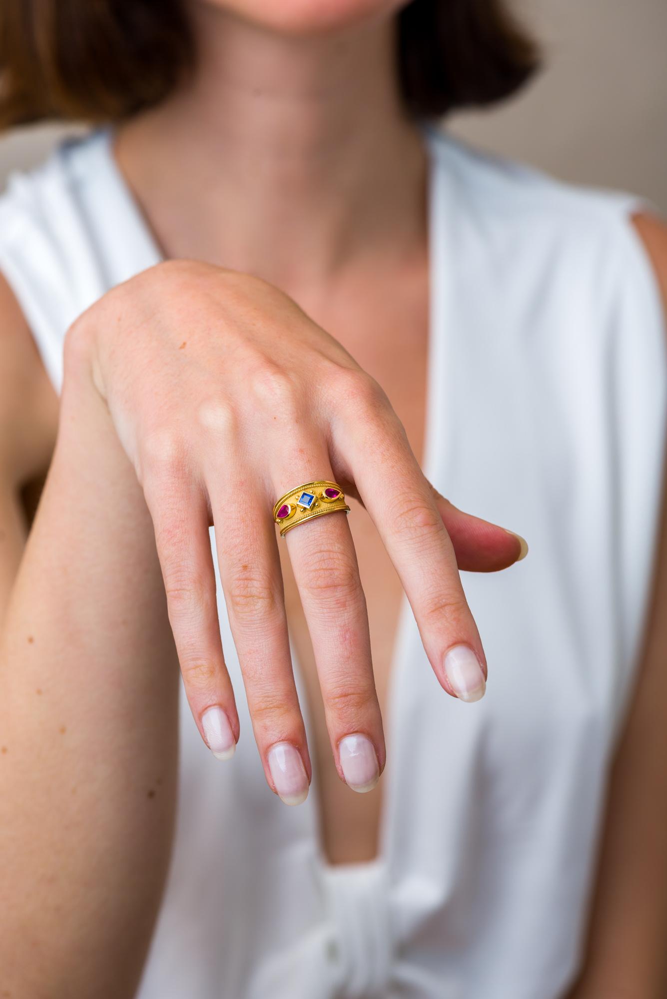 Cette exquise bague en or est une toile captivante, où deux rubis fuchsia en forme de poire enflamment l'imagination, et un saphir bleu carré plante le décor d'un conte enchanteur à l'élégance vibrante et à l'allure intemporelle.

100% fait à la