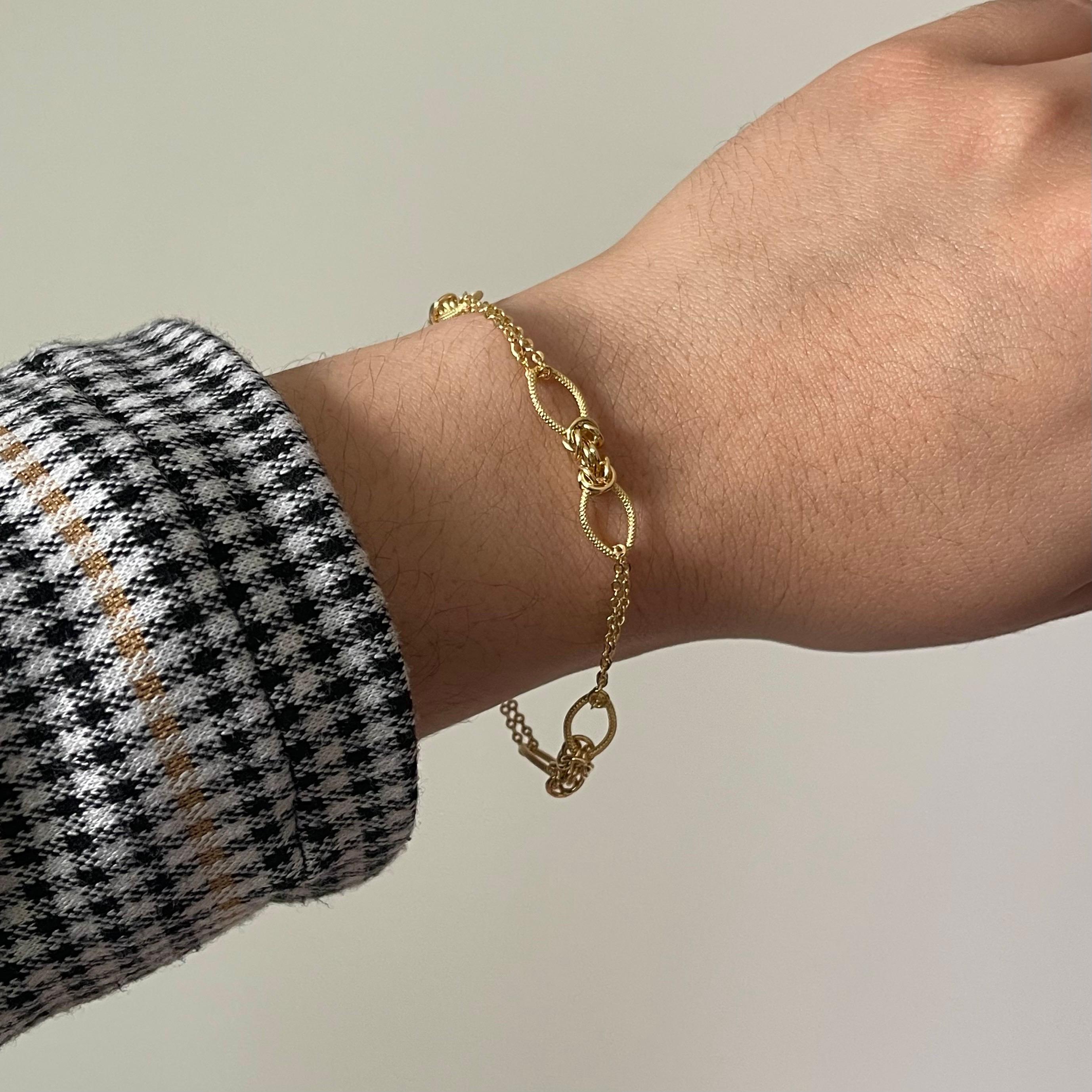 Questo sofisticato braccialetto in oro giallo 18 carati presenta una catena dal design intricato, che offre un'eleganza senza tempo perfetta per essere indossata ogni giorno o in occasioni speciali. Caratterizzato da charme delicatamente intrecciati