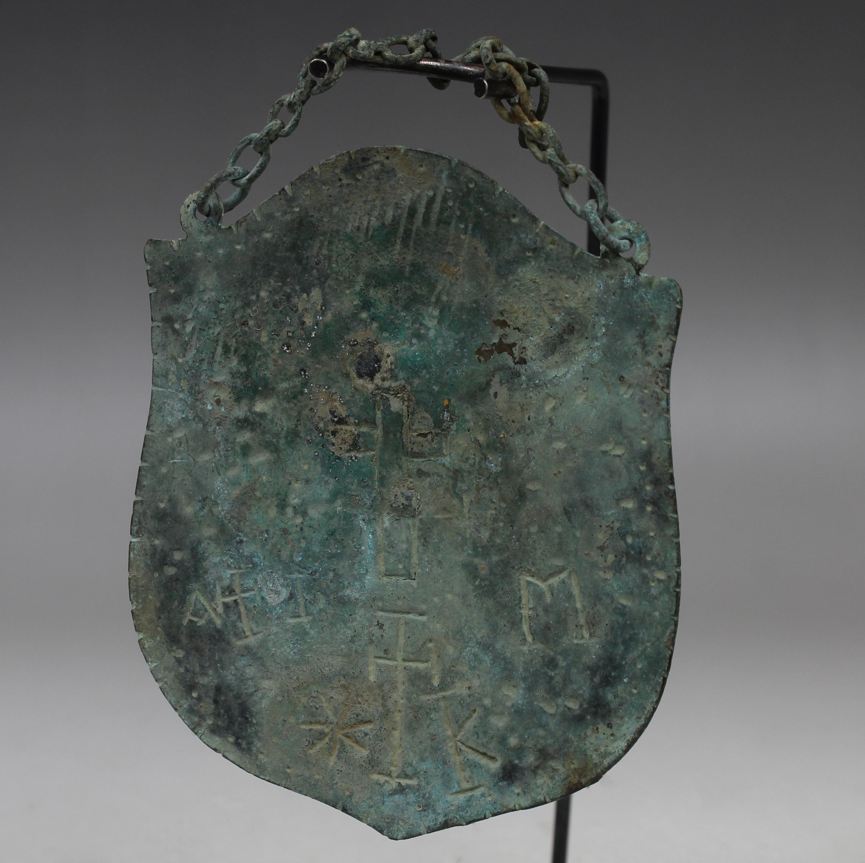 ITEM: Pilgrims badge / Plaque with incised cross and inscription with original suspension chain
MATERIAL: Bronze
CULTURE: Byzantine
PERIOD: 5th – 8th Century A.D
DIMENSIONS: 95 mm x 80 mm (without chain), 140 mm x 80 mm (with chain)
CONDITION: Good