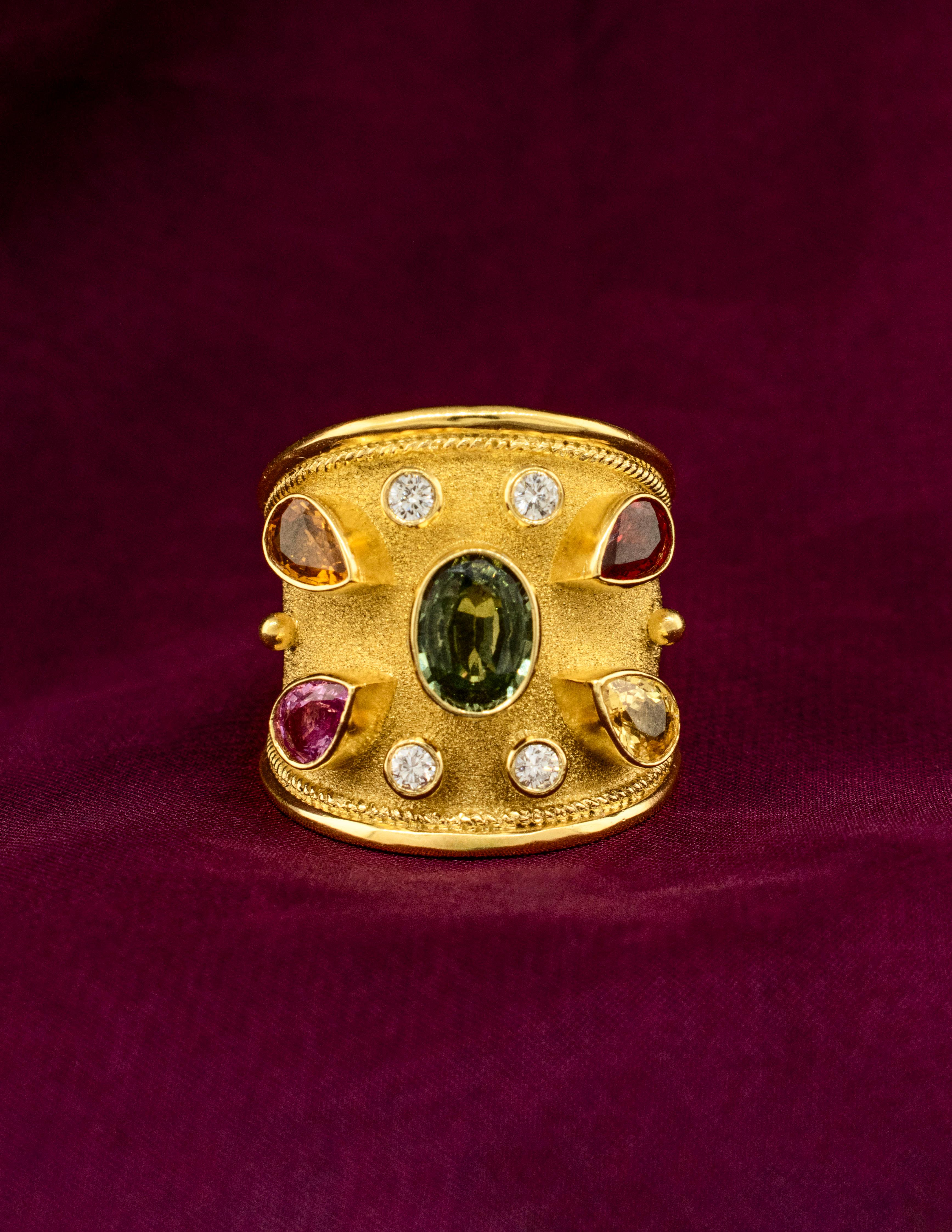 Brilliant Fancy Colored Sapphires make this Byzantine Ring Sparkle! Natural Sapphires in Deep Green, Honey Gold, Soft Lavender, Sunshine Yellow and Fiery Red are accentuated by matte 18k yellow gold with a rope border and polished edges. The bezel