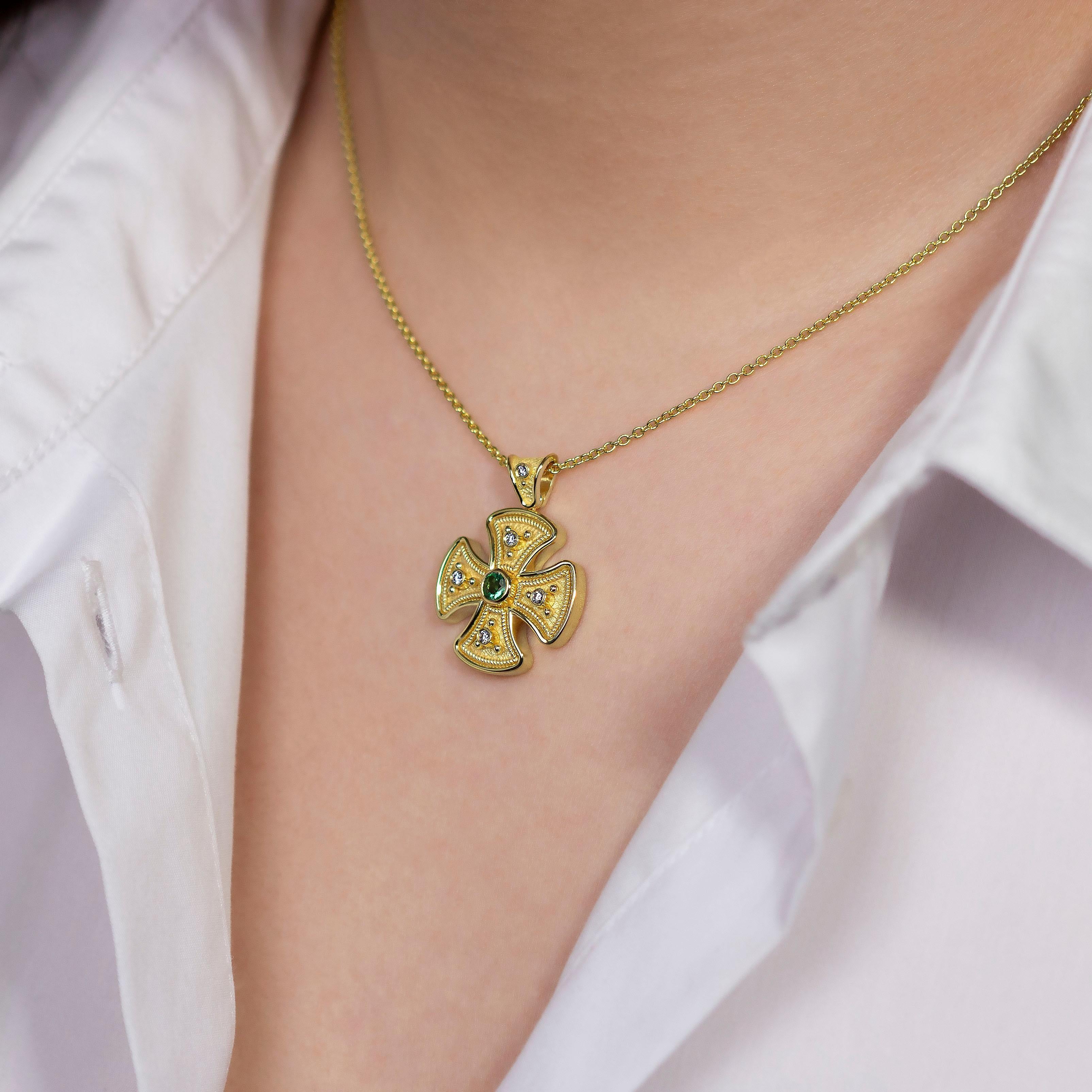 In the heart of our round gold cross pendant, a captivating emerald with its enchanting green hue takes center stage, surrounded by a brilliant constellation of diamonds—a radiant emblem of faith and timeless elegance that echoes the lush beauty of