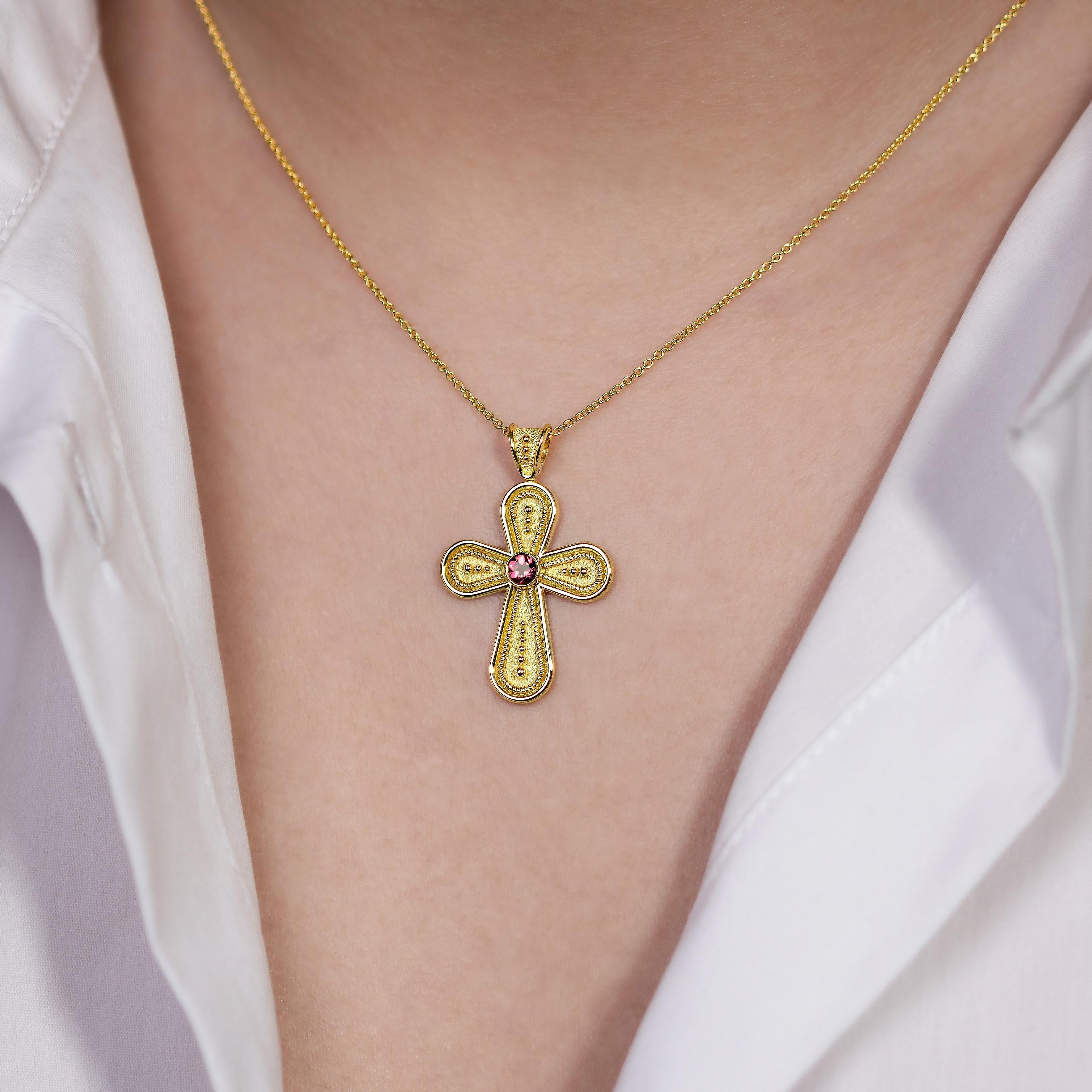 Adorn yourself with a rounded cross pendant, where a serene pink tourmaline graces the center amidst a gradient of delicate granulations—a beautiful symbol of faith and graceful elegance.

100% handmade in our workshop.

Metal: 18K Gold
Gemstones: