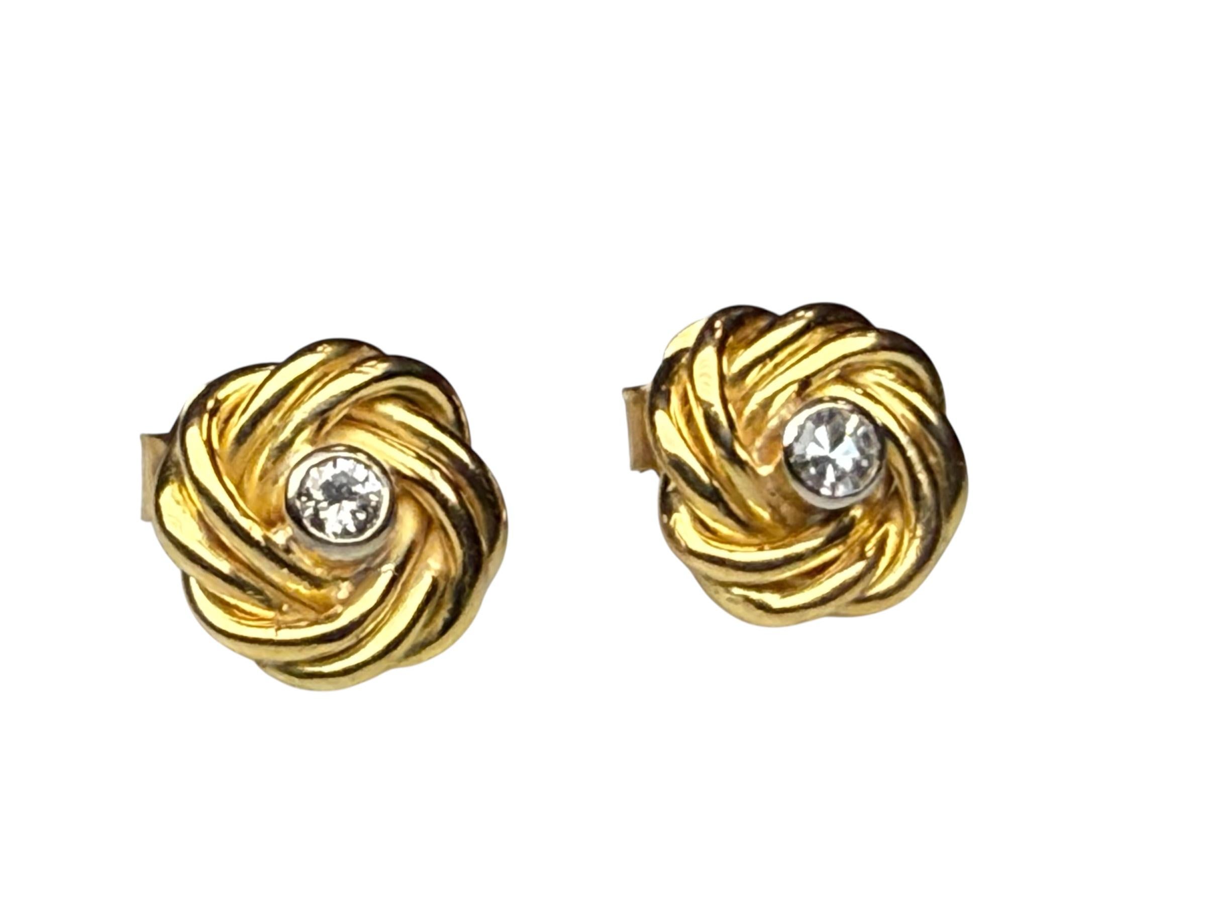 Il s'agit d'une paire de boucles d'oreilles en or 18 carats et diamants. Elle représente une paire de boucles d'oreilles en or ornées d'un total de 0,20 carats de diamants sur des montures à chaton et pesant 3 euros.