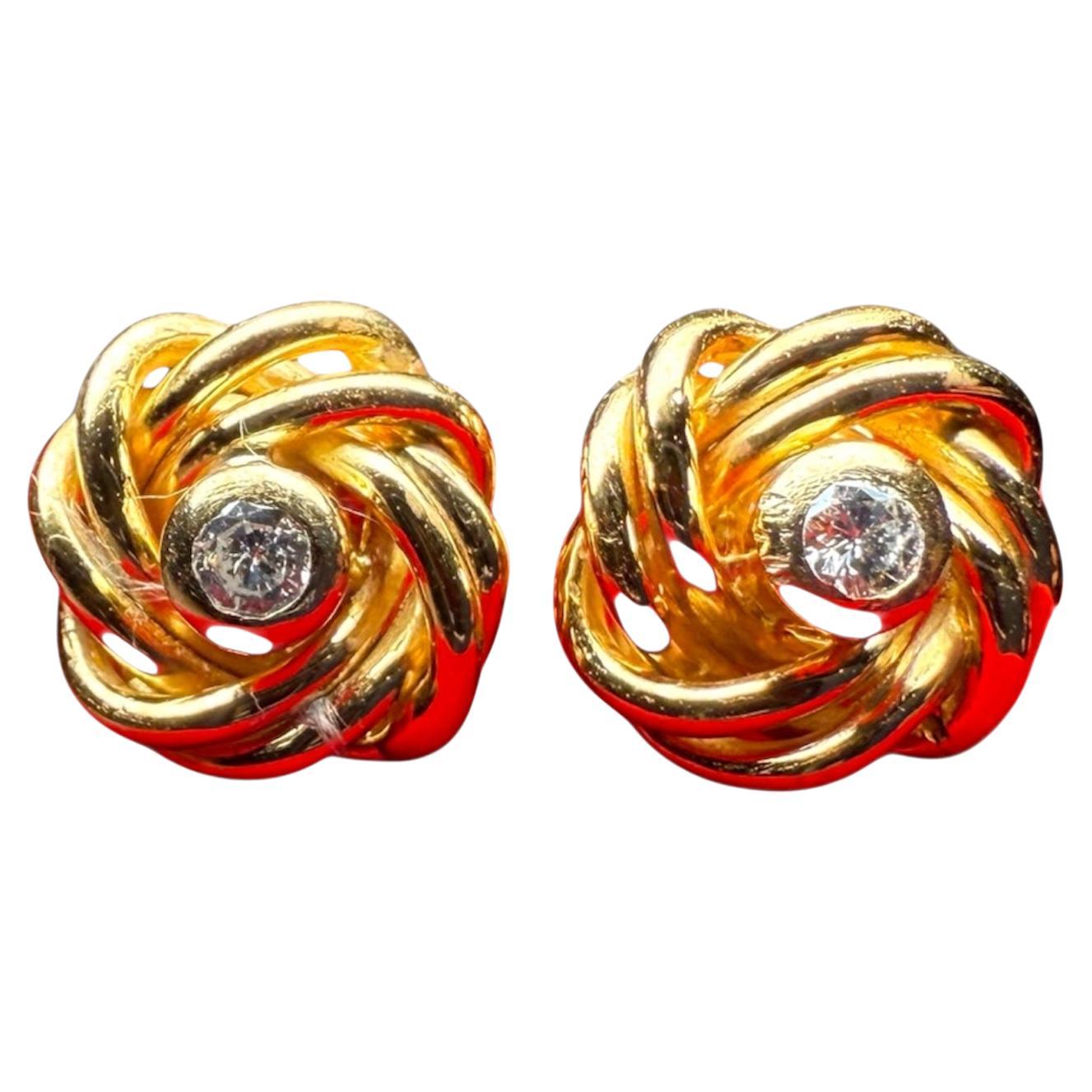 Si tratta di un paio di orecchini in oro 18 carati e diamanti. Si tratta di un paio di orecchini a nodo in oro con un totale di 0,20 carati di diamanti su castoni e un peso di 6,3 grammi.