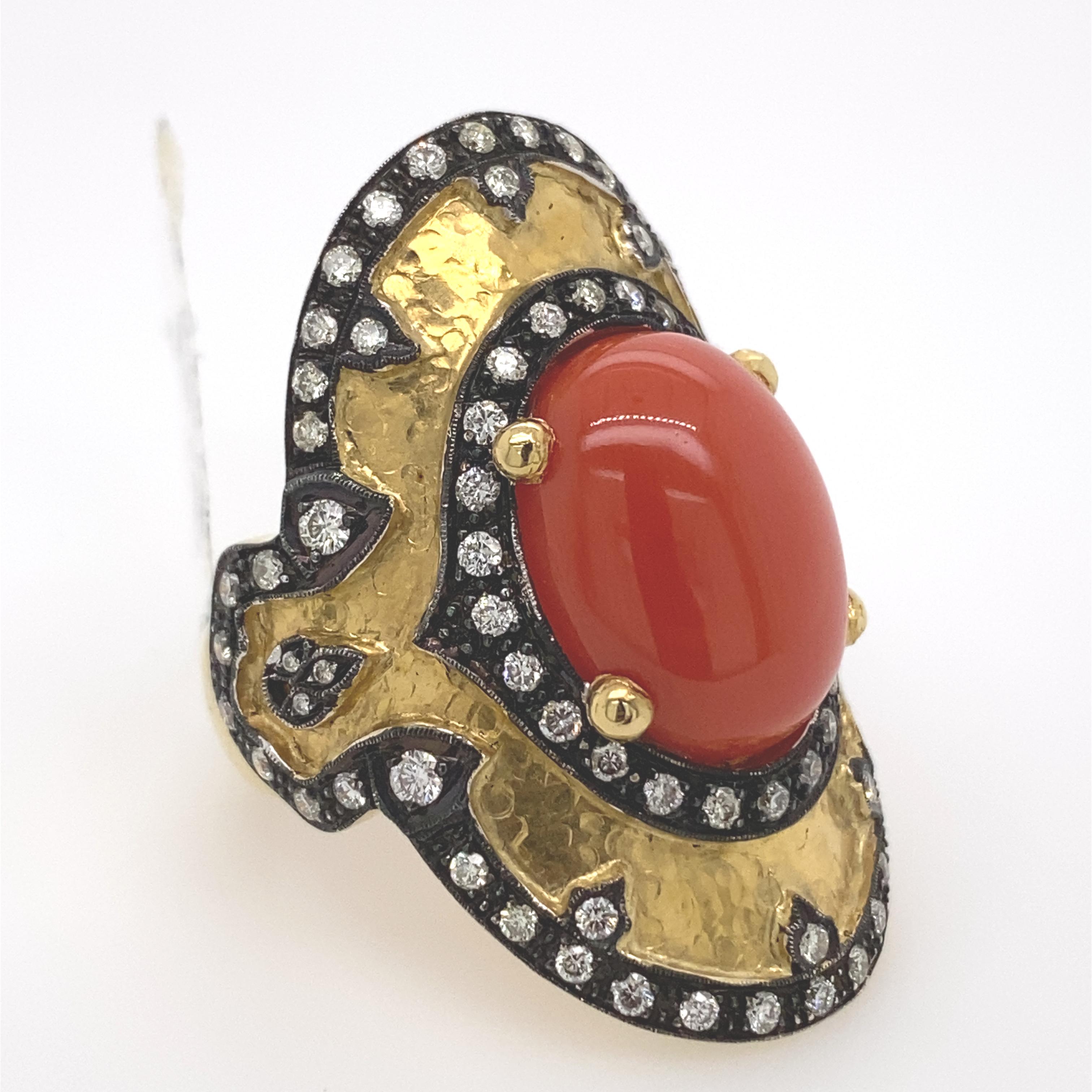 Byzantine inspired coral and diamond hammered ring. 
Oval coral complimented by 1.22ct of round cut diamonds. 18k yellow gold, hammered finished with black rhodium.
Accommodated with an up to date appraisal by a GIA G.G., please contact us with any