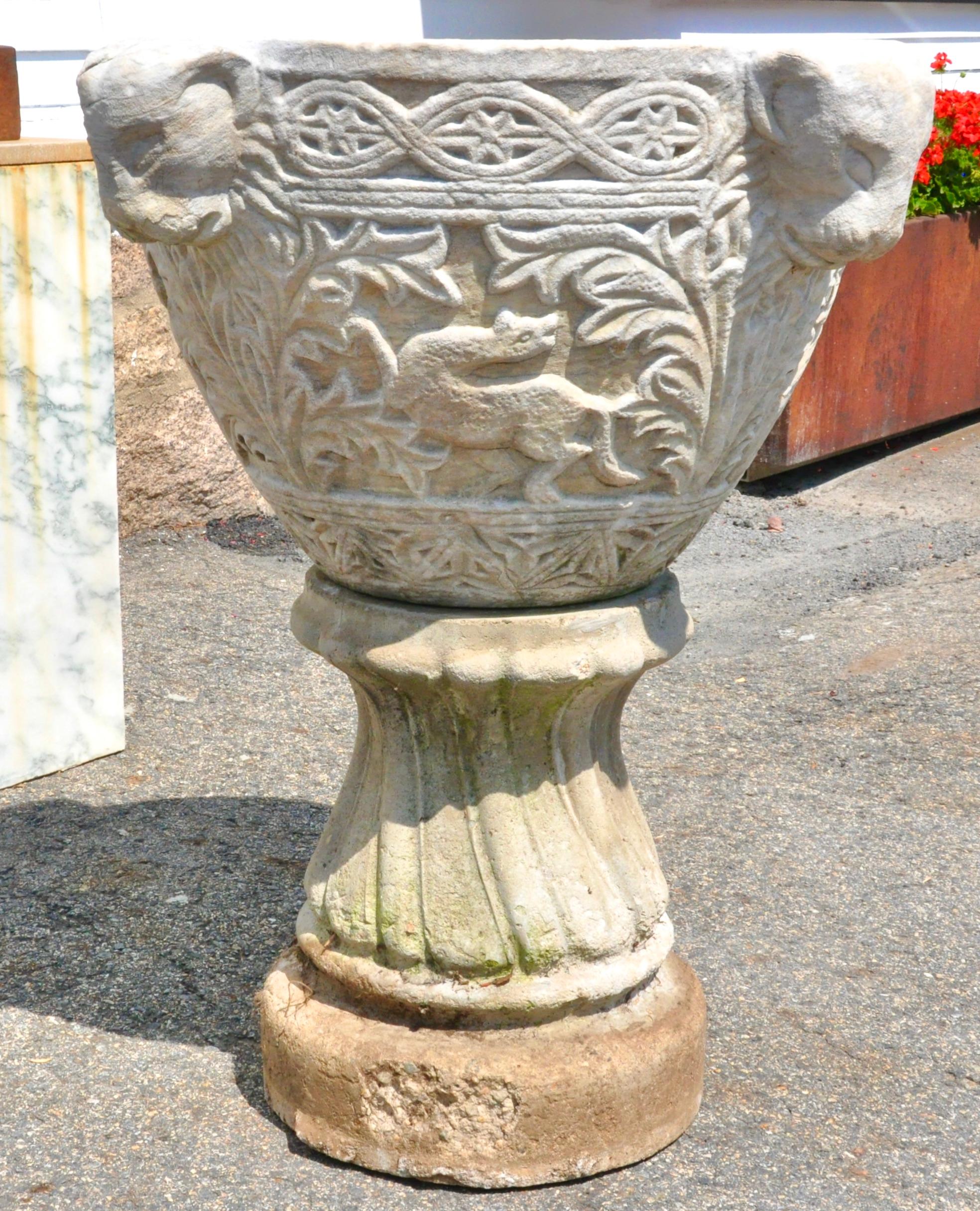 Byzantine style carved marble Baptismal font on later cast stone stand. Four lion leads Circumnavigate the font. Foliate and Byzantine Carving Throughout. Each side with Zoomorphic Symbolism including a Serpent, Peacock, Lioness. Weathering but
