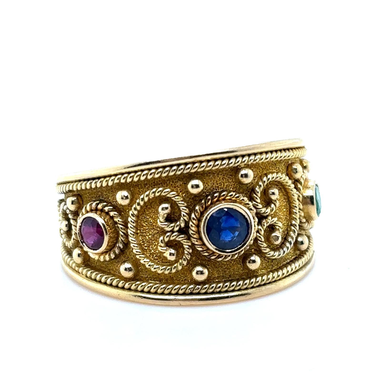 A retro Byzantium Style Emerald Sapphire Ruby Ring 18 Karat Yellow Gold, circa 1990.

This Byzantine style ring is bezel set with a round cut sapphire of 0.18 carat approximately to its centre, framed by a round cut emerald of 0.08 carat and a round