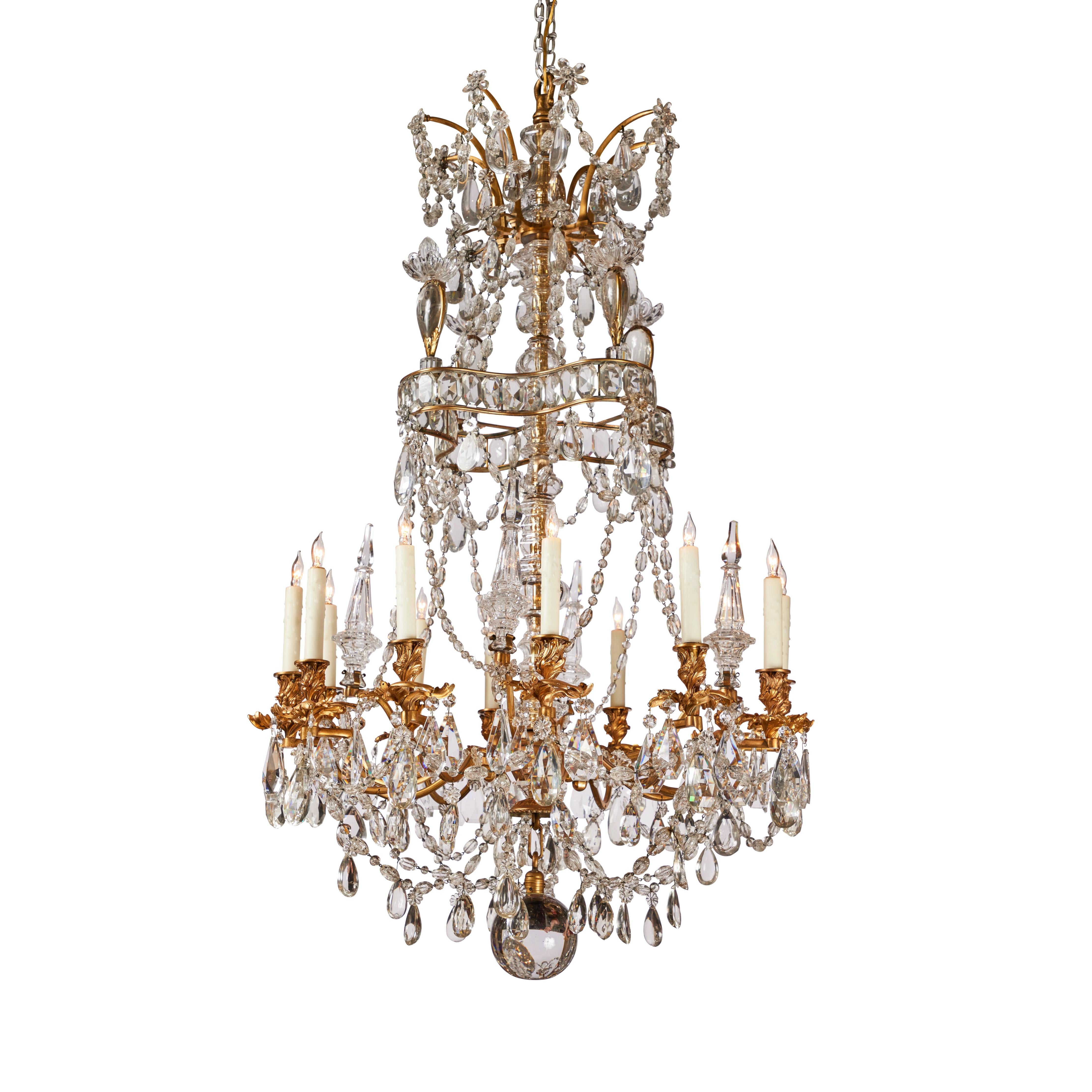 A elaborately appointed, hand-cast, gilt bronze carriage, 12-light chandelier decorated in multiple tiers of faceted and smooth polished crystal. Each of the arms terminating in remarkable, twisting, foliate-form bobesh and candle cups. The upper