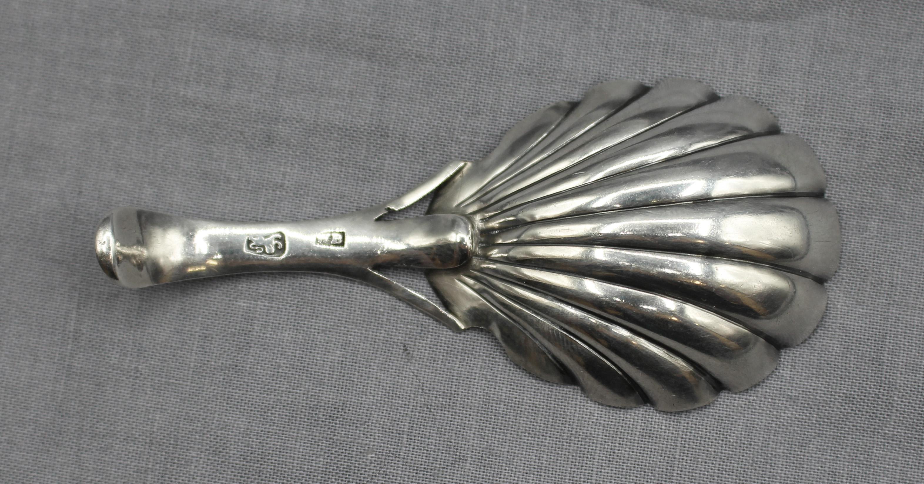 Cucchiaio da tè in argento sterling di Londra del 1770-80 circa. Intricata decorazione a taglio vivo e ciotola con conchiglia. Marchio del produttore WB, probabilmente Walter Brind. È documentato un esemplare identico con datario del 1785. Piccola