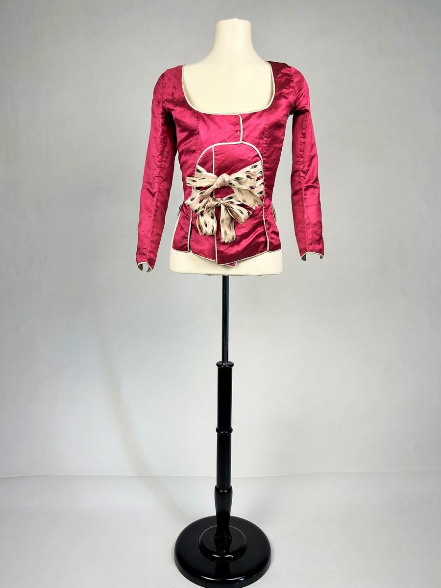 Circa 1780
Provence
Pierrot or Caraco à la Suzanne in reference to The Mariage de Figaro (1778) from a private mansion in Aix en Provence dating from the Louis XVI period. Raspberry satin with white piping. English-cut with three-quarter bent