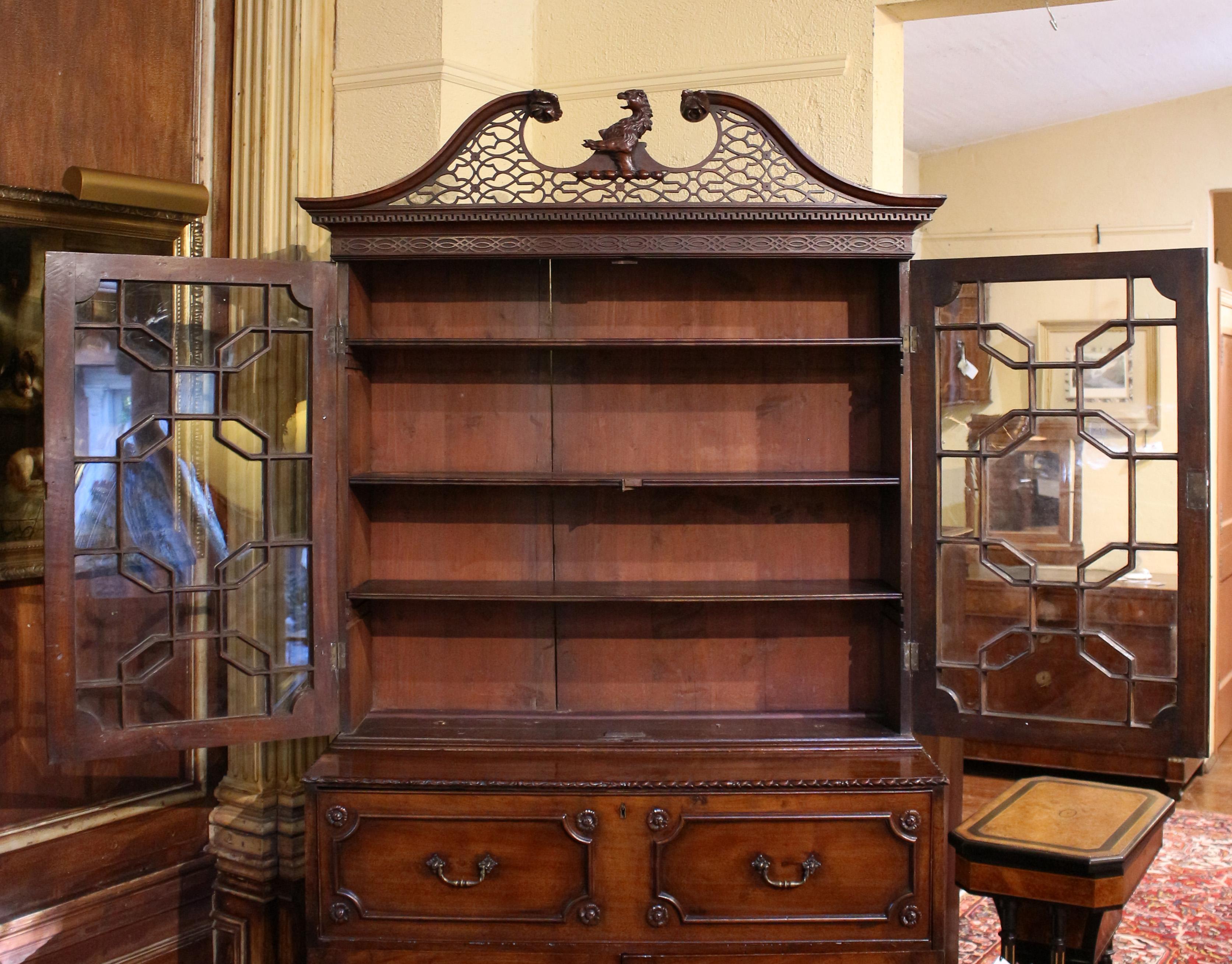 Circa 1780 George III Armorial Crested Secretaire Bookcase, English. This monumental, important secretaire bookcase is surmounted by a superb fretwork broken arch pediment with central armorial crest. The bookcase doors with 23 glazed panes of