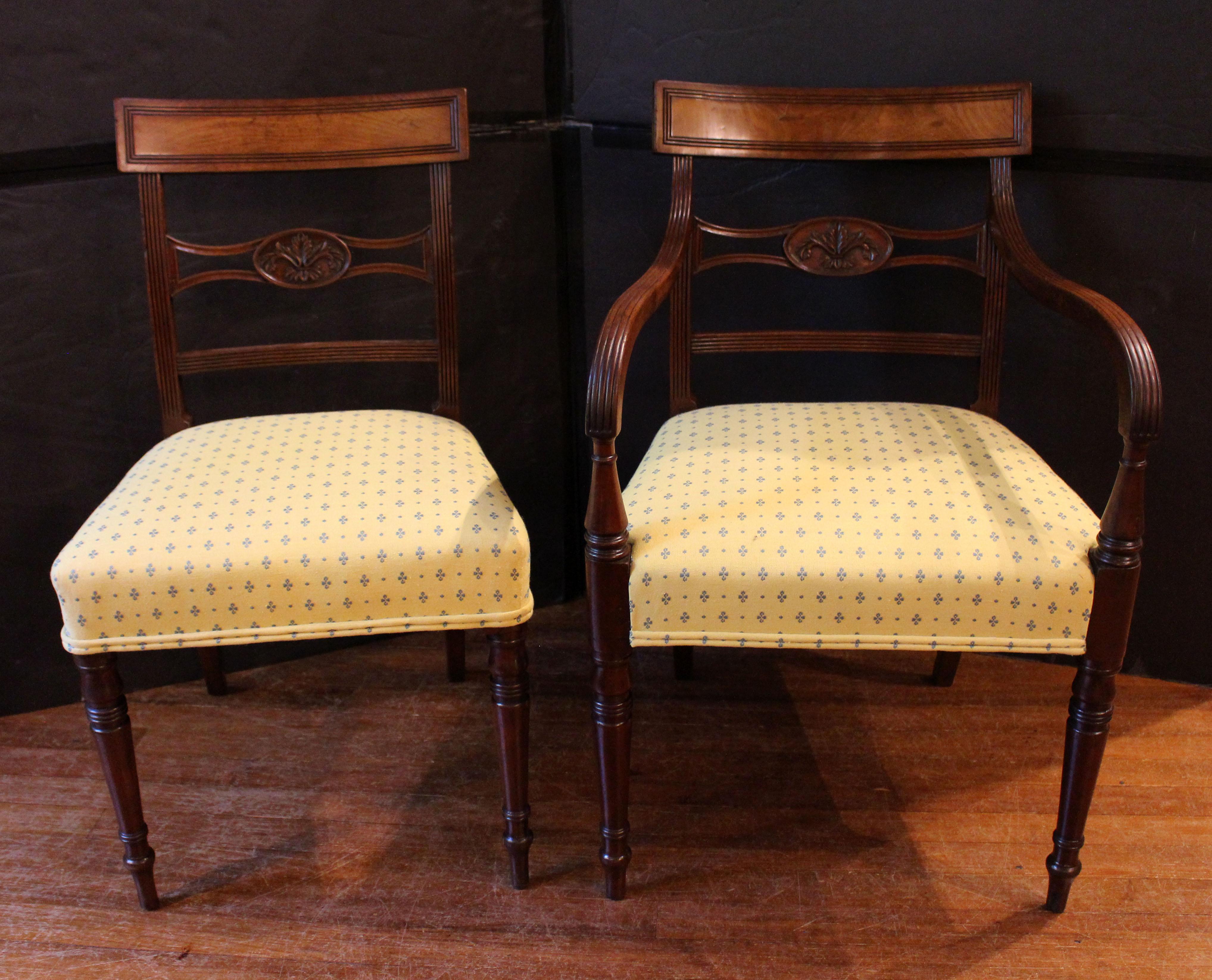 Circa 1795 Sheraton design set of 8 dining chairs, English. Mahogany. Of the highest quality with graceful turned, tapered legs, reeded stiles, reeded framing of crest rails & of the elegant carved medial back rails with acanthus carved oval. The