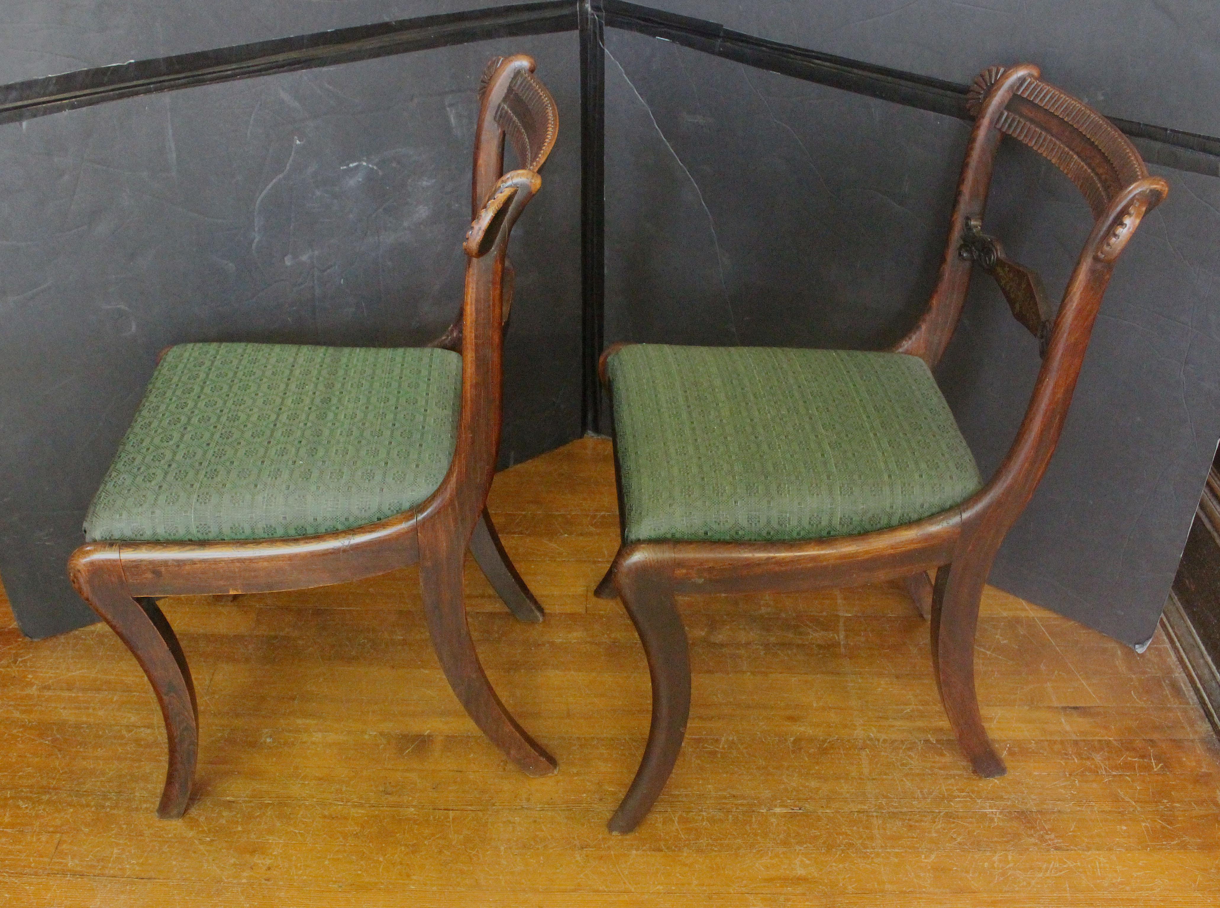 Circa 1810 pair of painted Regency side chairs, English. Painted on beech to simulate grained rosewood. Handsome brass inlays & superb carving. Raised on saber legs. Horse hair green damask slip seats.
18