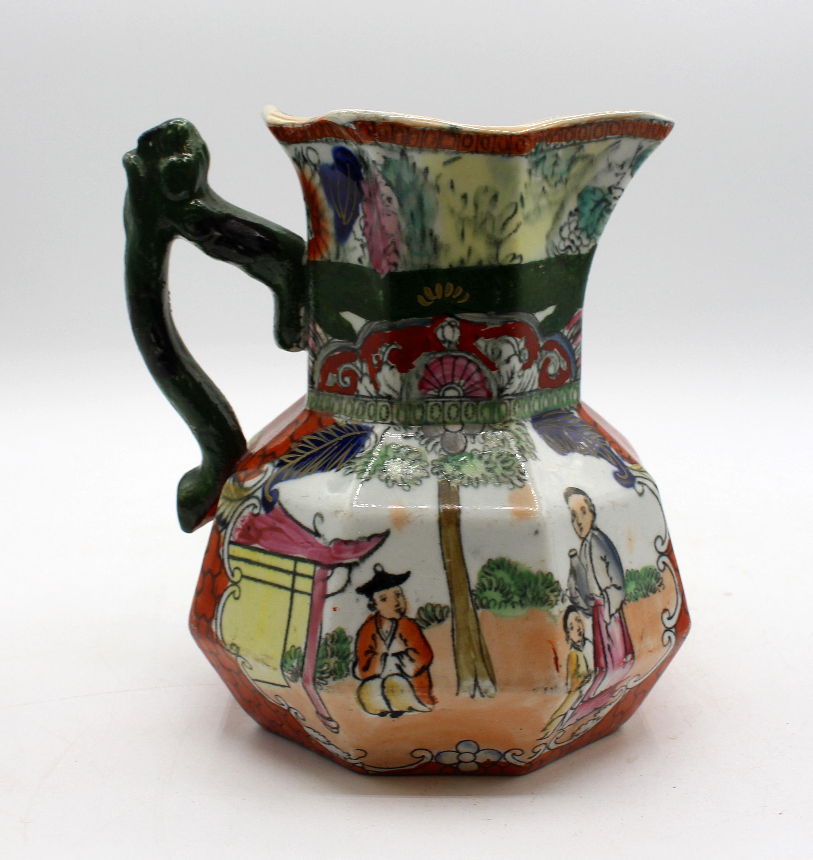Circa 1830-48 large Mason's ironstone red scale Chinoiserie jug or pitcher, English. Marked in black: Mason's Patent Ironstone China; with swag banner & crown. Octagonal with twig handle. A conversation group on each side by a tea house. Burnt