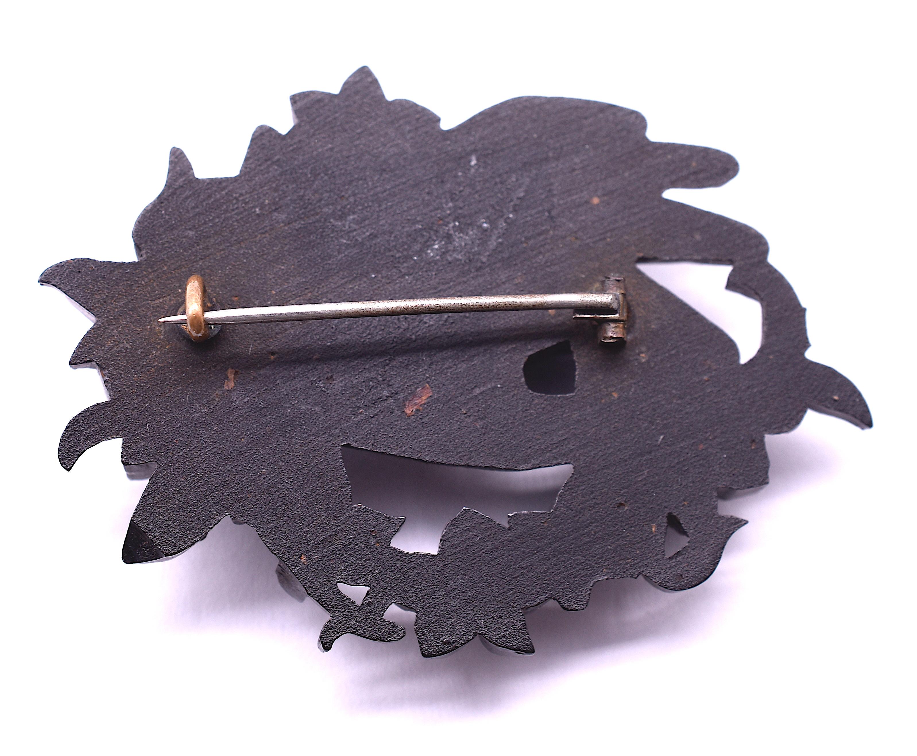Intricately carved, our hand- carved hand brooch is made up of a material called Bog Oak. Bog Oak is a type of peat that is native to Ireland; the Irish are quite proud of their bog oak jewelry. It resembles wood and has slight graining, usually