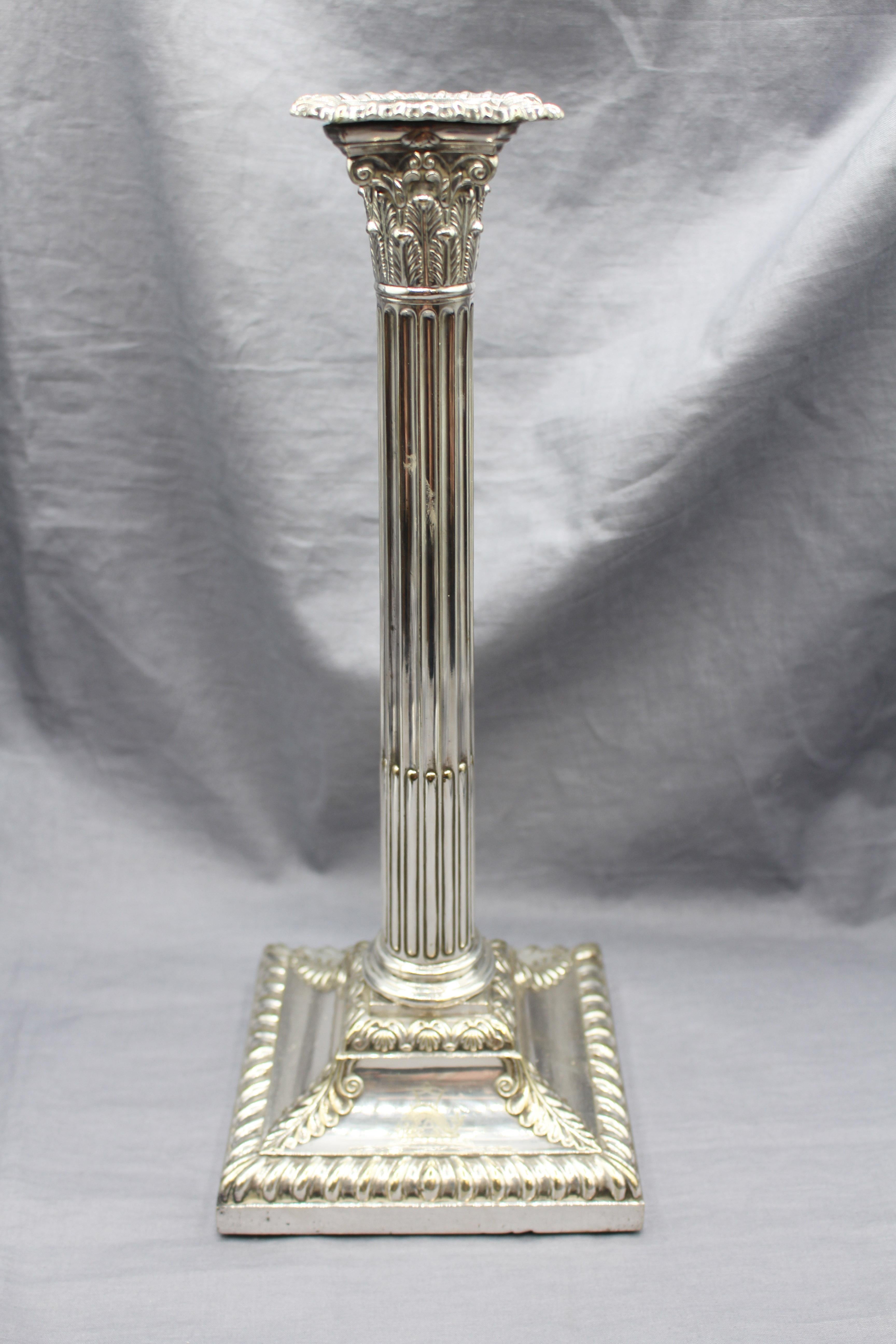 Circa 1853-67 silver plate on copper pair of Armorial candlesticks, English. Classical design in Corinthian column form with stop-fluting; gadroon & shell borders; acanthus leaf corners. The crest is of a dolphin over a pair of flagged arrows,
