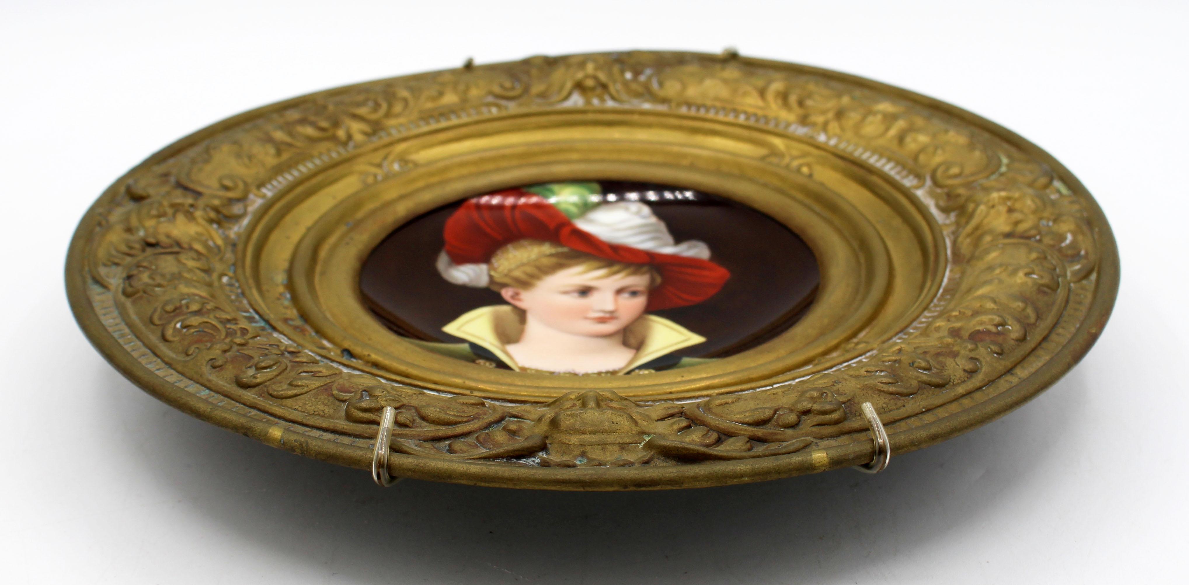 CIRCA 1870-1900 bemalte Porzellanplakette in Messinghalterung, kontinental. Wiederbelebung der Renaissance. Charmant von Hand gemaltes Bild einer Frau in Theaterkleidung. Einfassung aus gestanztem Messing.

Ø 11 1/8