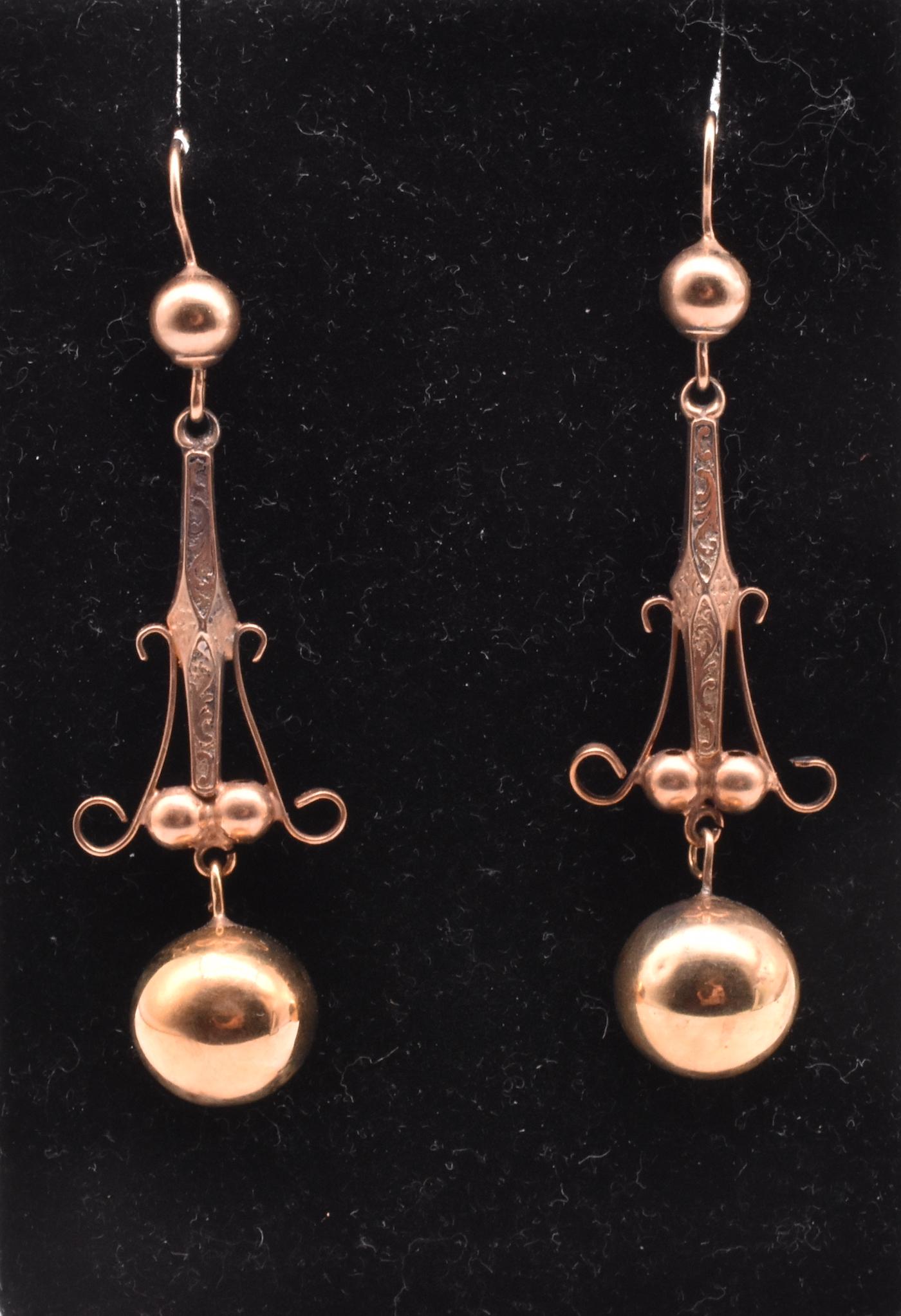 Elegant 9K Victorian rose gold colored earrings with a gold ball dangling from the central part of the earring. The ball is repeated in the tops of the earrings, middle, and the very bottom. The original shepherds hook attachment allows for the