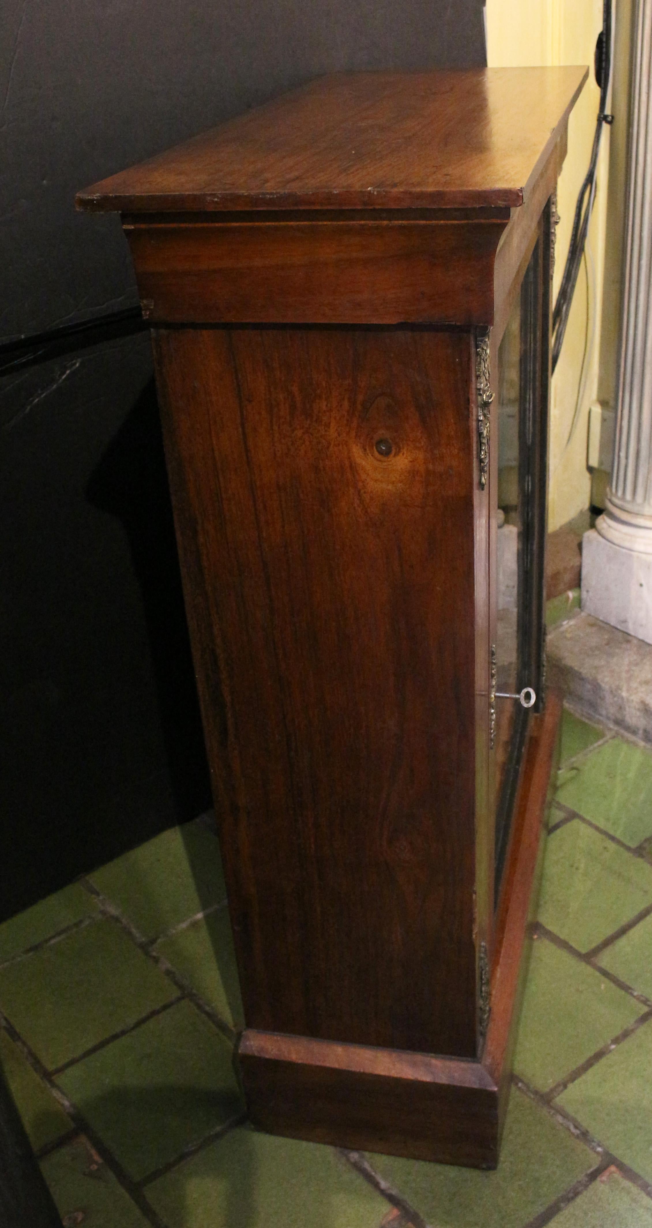 Circa 1870 Victorian glazed door bookcase cabinet, English. Noyer. Montures de pilastre en laiton. Incrustation complexe sur le panneau au-dessus de la porte et incrustation de la ligne de la porte et des pilastres. Elle a conservé ses garnitures en