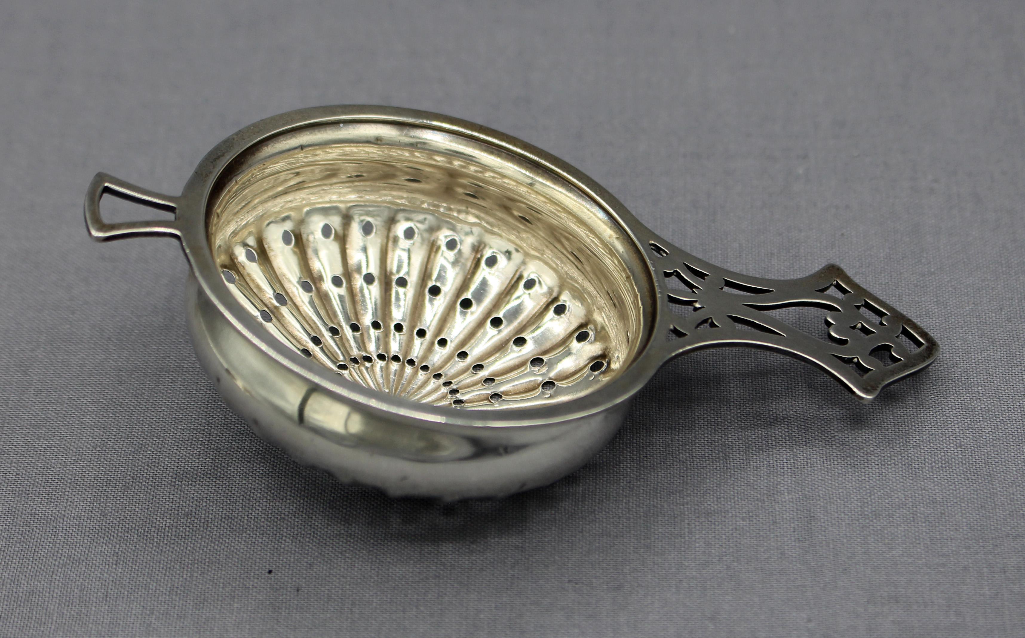 Sterling silver tea strainer with silver plated stand, American & English, c.1890-1920. The strainer is American sterling silver while the stand is English silverplate by Webster. Pierced handle & conforming pierced stand.
Overall: 3
