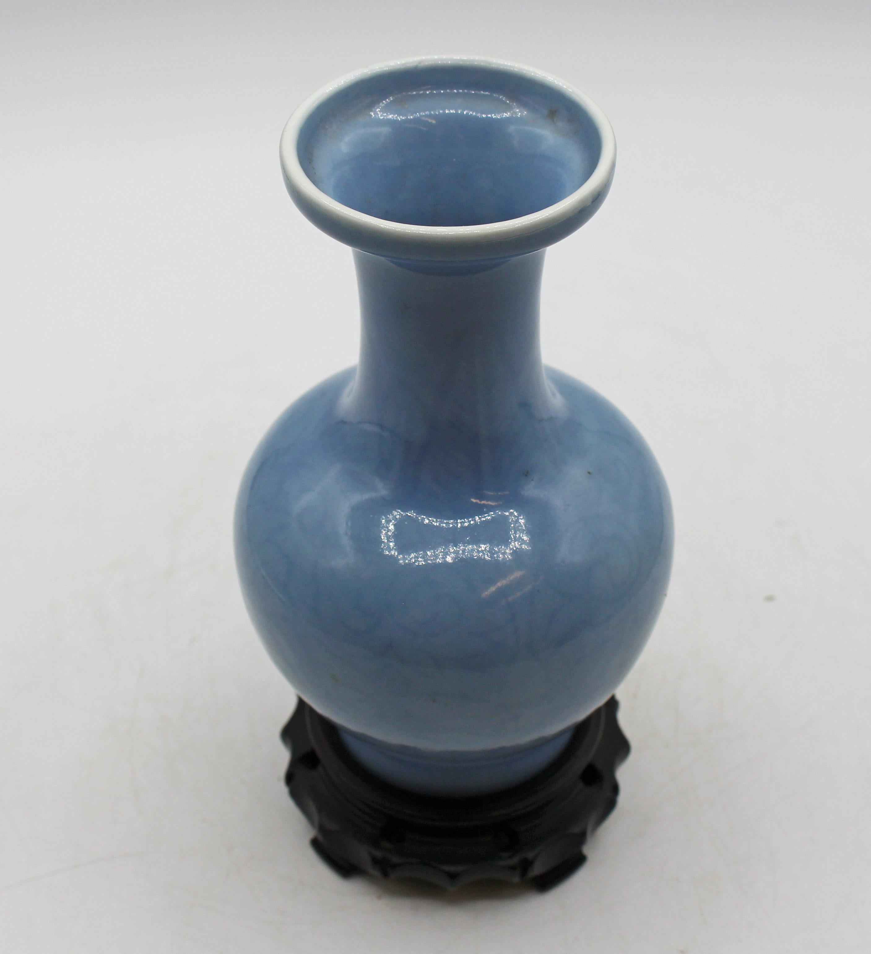 Circa 1891-1911 Vase en porcelaine chinoise bleu clair à glaçure claire-de-lune. Décor naturaliste en bleu sous glaçure, léger et dispersé. Maintenant avec un support sculpté attaché, car il a été percé comme une lampe à un moment donné. Vase de 6