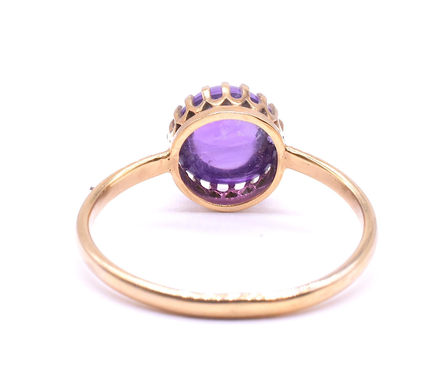 We love the simplicity of this claw set amethyst single cabochon stone ring, made somewhere around the turn of the century or later. The ring is hallmarked 15K and has 3 decorative notches cut on both sides of the band.  The single cabochon amethyst