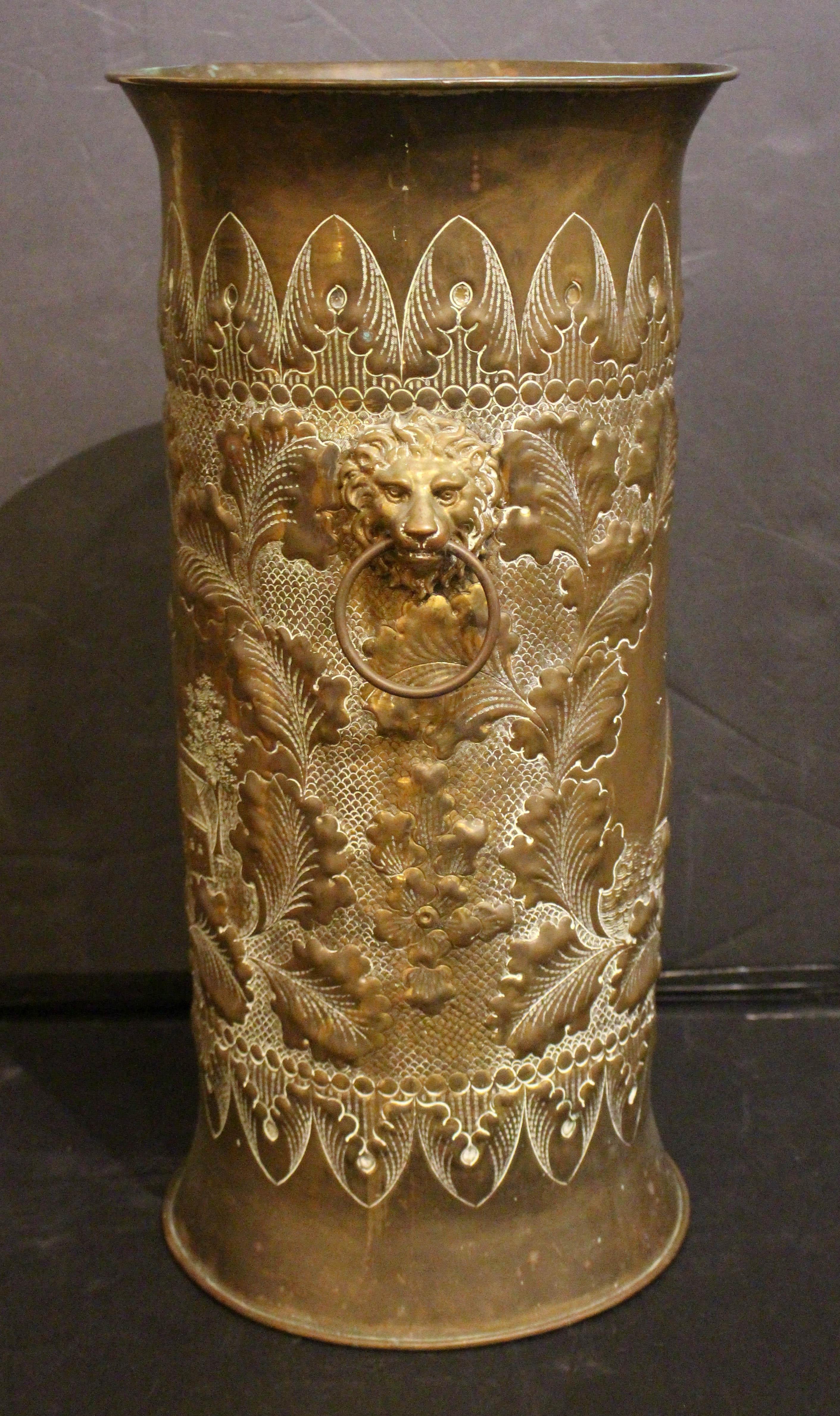 Circa 1900 Dutch brass repousse stick or umbrella stand. Abundant repousse leaves & lappets with detailed lion mask ring handles. Central cartouches of a sailboat reversing to a large windmill & town.
21.25