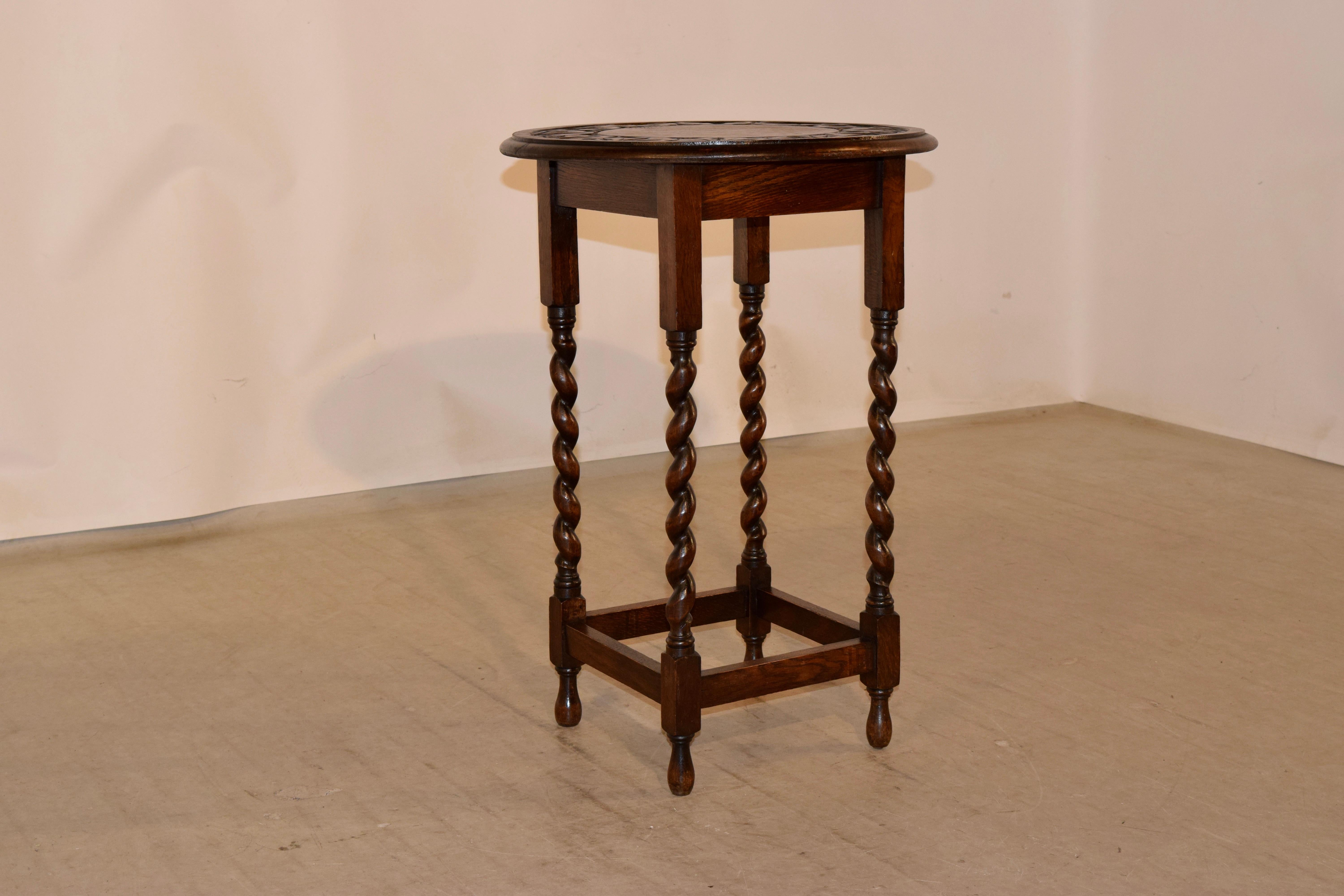 English oak occasional table with a beveled edge around the top and carved banding, following down to a simple apron, over hand turned barley twist legs, joined by simple stretchers. Raised on hand turned feet, circa 1900.