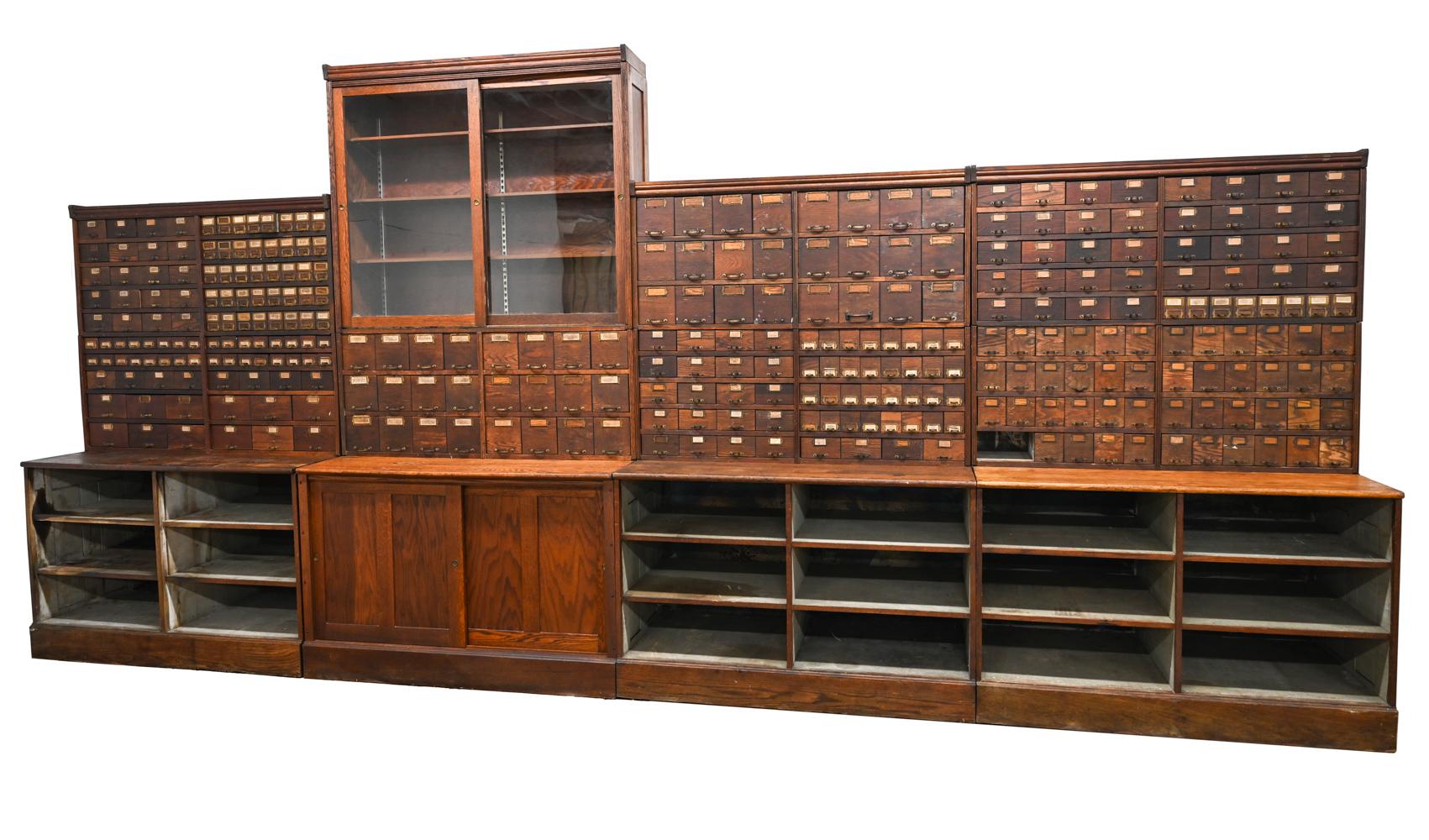 A fantastic, monumental oak wood wall unit ordered by Bradburn Bros. for an early Harley-Davidson dealership in Canandaigua, N.Y., c. 1900, for use in storing parts for repair of motorcycles and bicycles. 
This impressive cabinet was made by