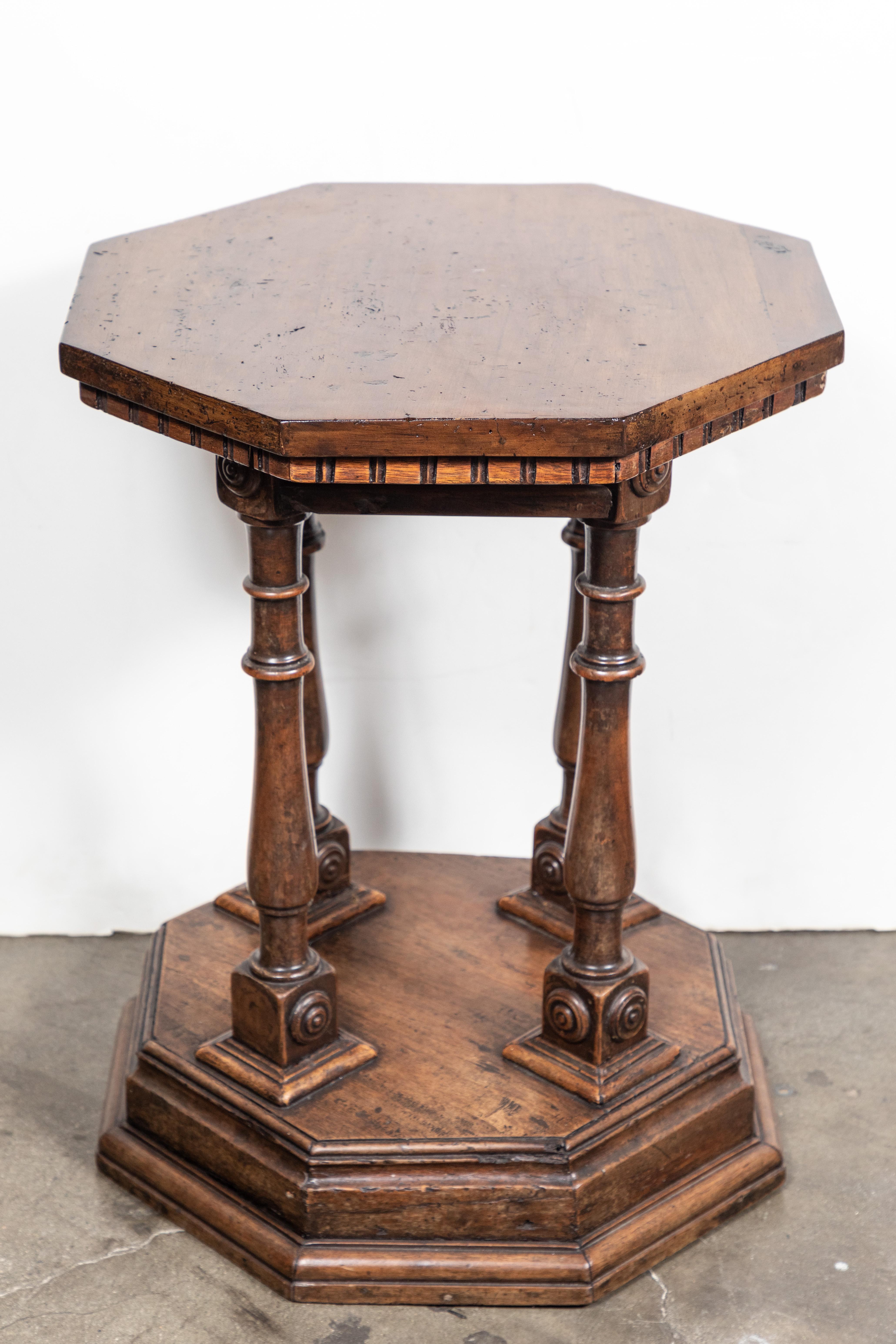 Turn-of-the-century, hand carved, octagonal, Tuscan, walnut side table with turned legs, egg and dart edging, all on a stepped base.