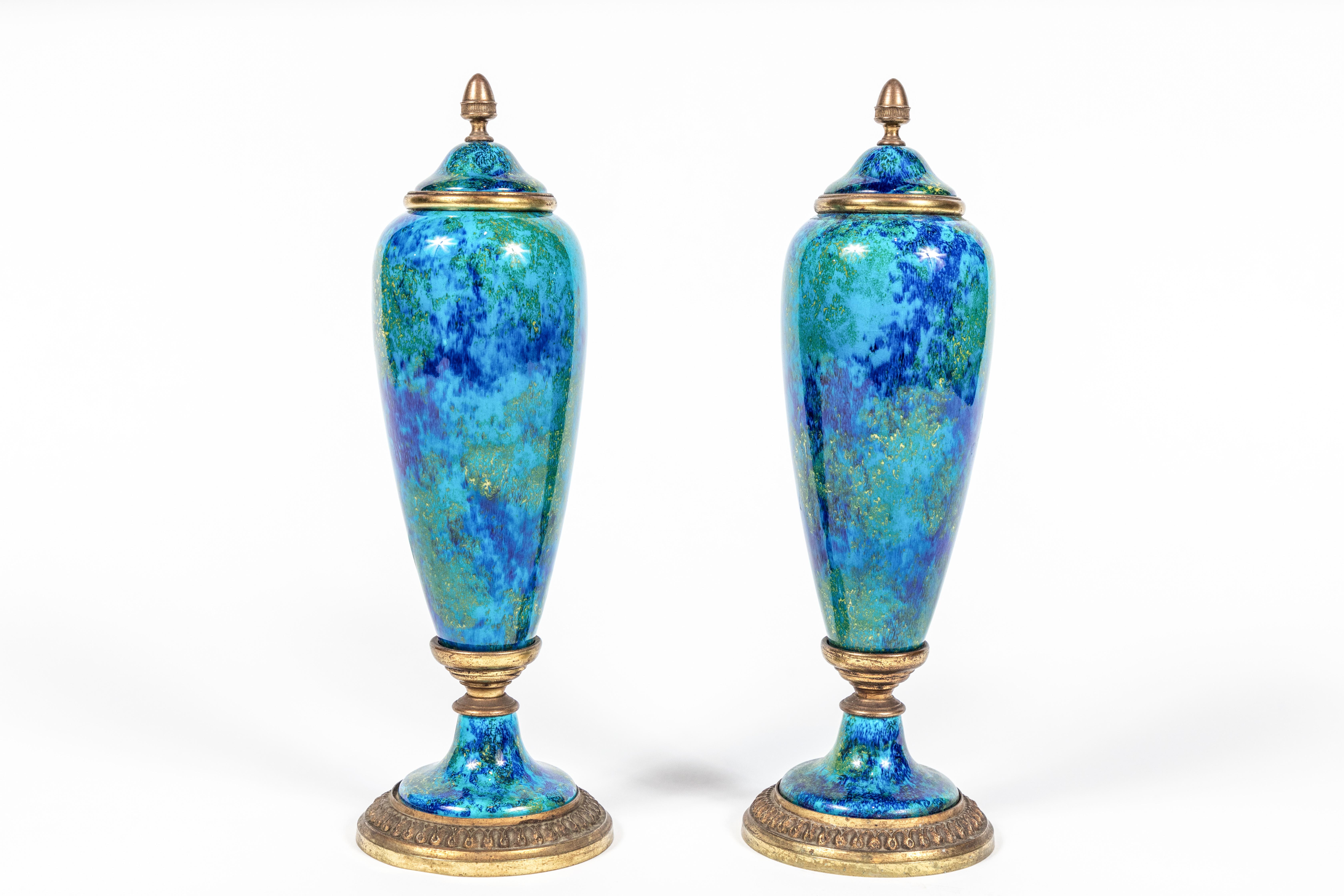 Striking pair of hand painted and glazed urns with gilt bronze mounts. Marked 