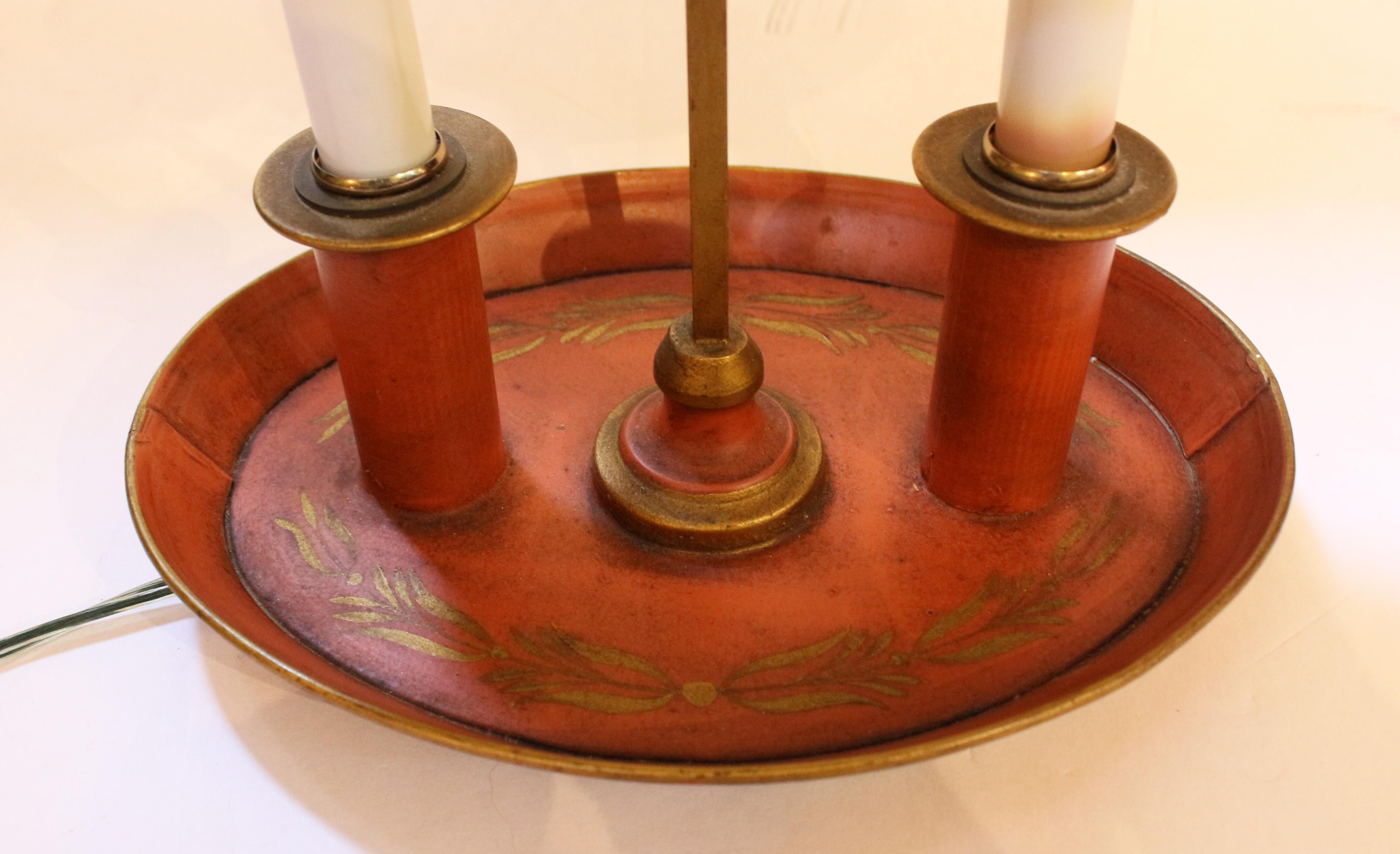 Circa 1920-30s French tole bouillotte lamp. Charmingly hand painted in burnt orange & gilded in the Classical taste. Marked Made in France. Ring finial & arrow feather end motif adjuster for the shade height. 9.5