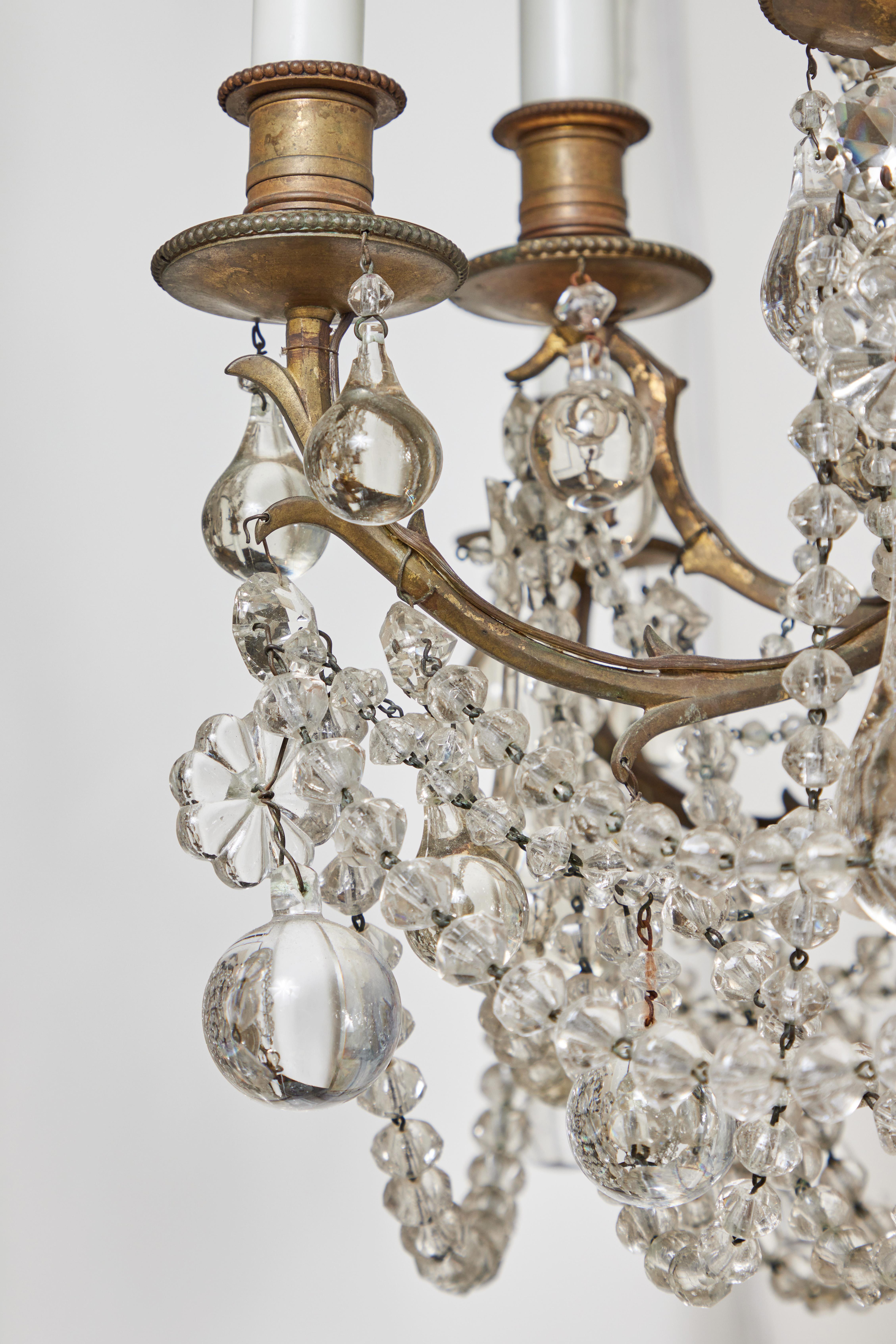 Absolutely charming, lush, c. 1920 Italian chandelier with a 12 light, gilt bronze carriage featuring branch-form arms. The whole filled with densely packed crystal swags and drops. Wired for U.S. current.