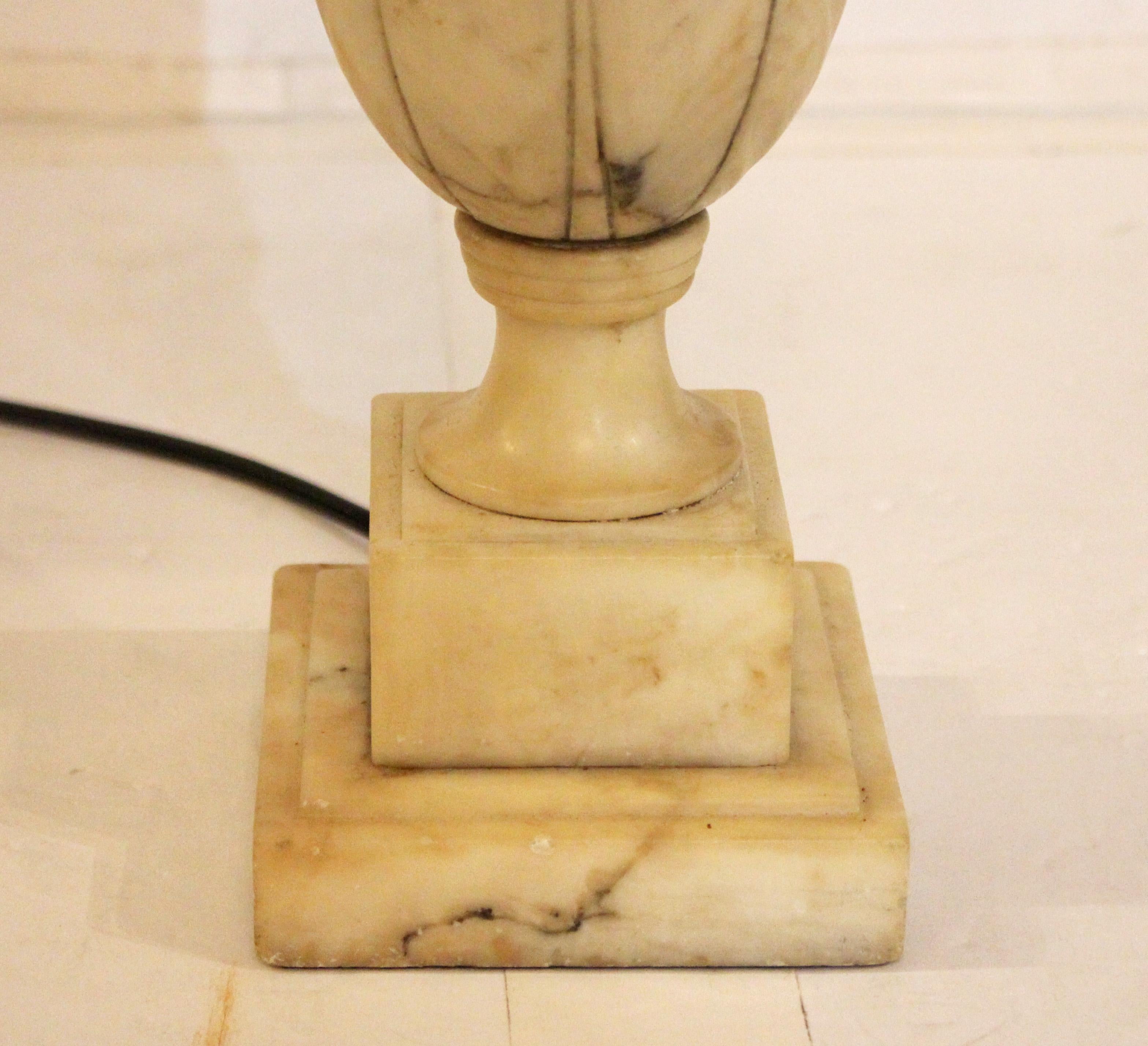 Lámpara de alabastro tallado en forma de urna de los años 1920-30, italiana. Atrevidamente tallada con 4 grandes hojas que crean un efecto de lapeado. Borde moldeado, base escalonada y cuadrada.
Base cuadrada de 4,25